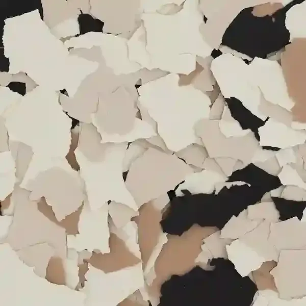 Peeling white paint flakes revealing dark underlayer on a beige surface