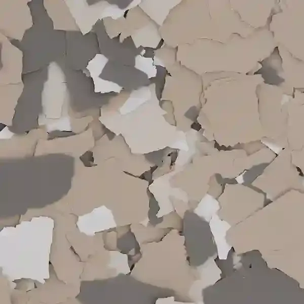 Peeling beige and gray paint flakes on a cracked wall surface