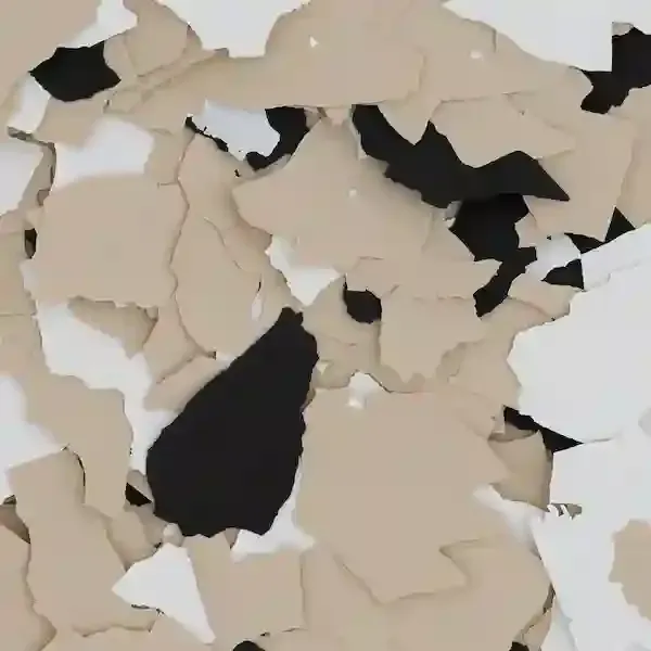 Beige and black peeling paint chips on a white surface