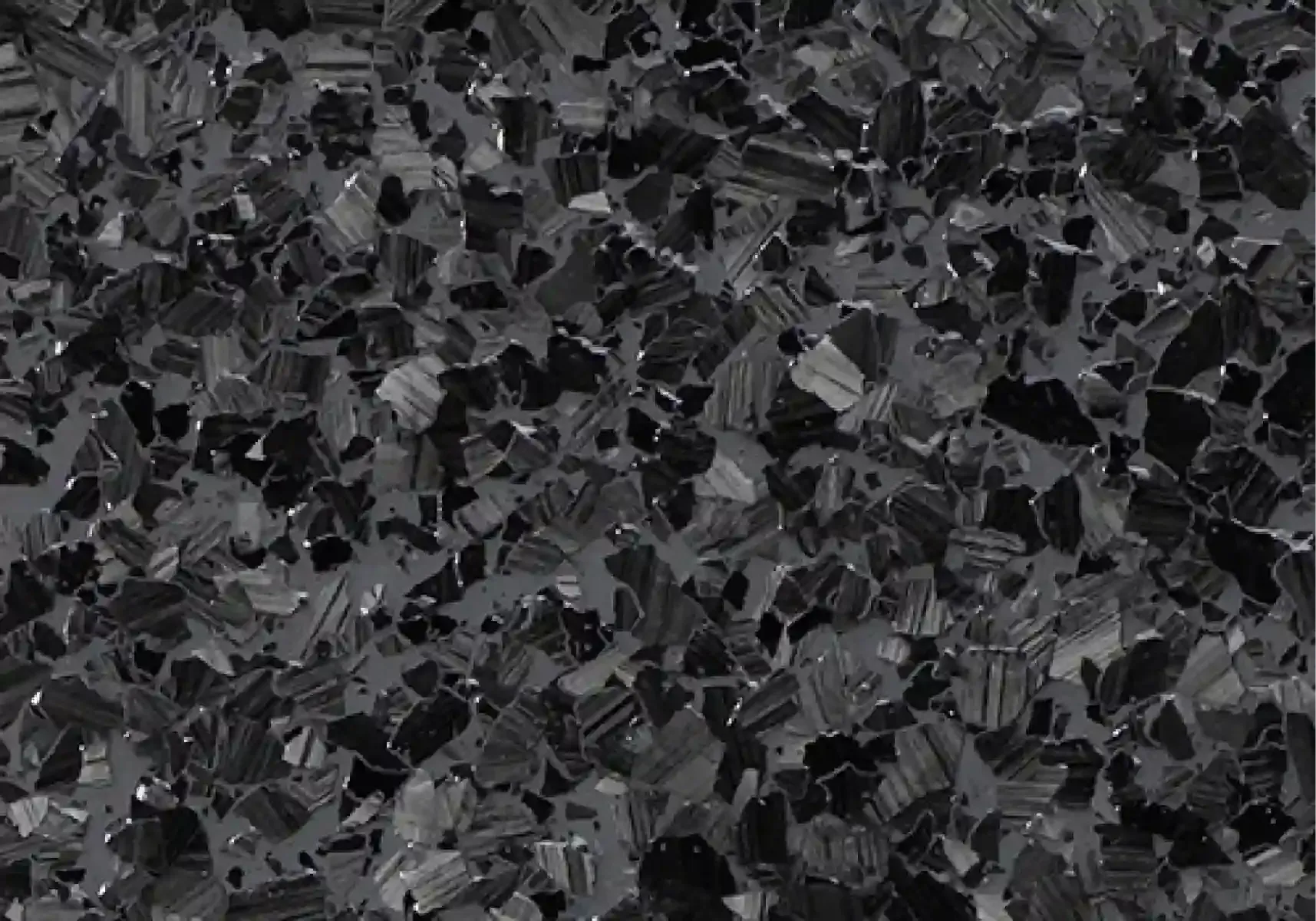 Close-up of a dark gray and black textured surface with scattered angular fragments