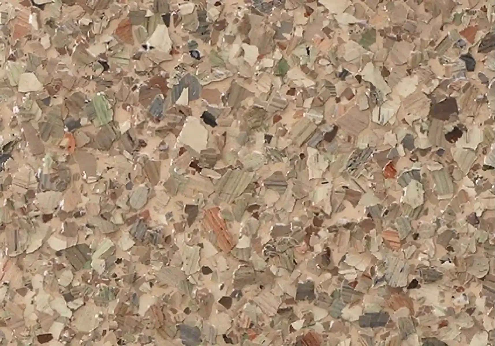 Close-up of a tan and gray speckled stone or tile surface with a rough texture