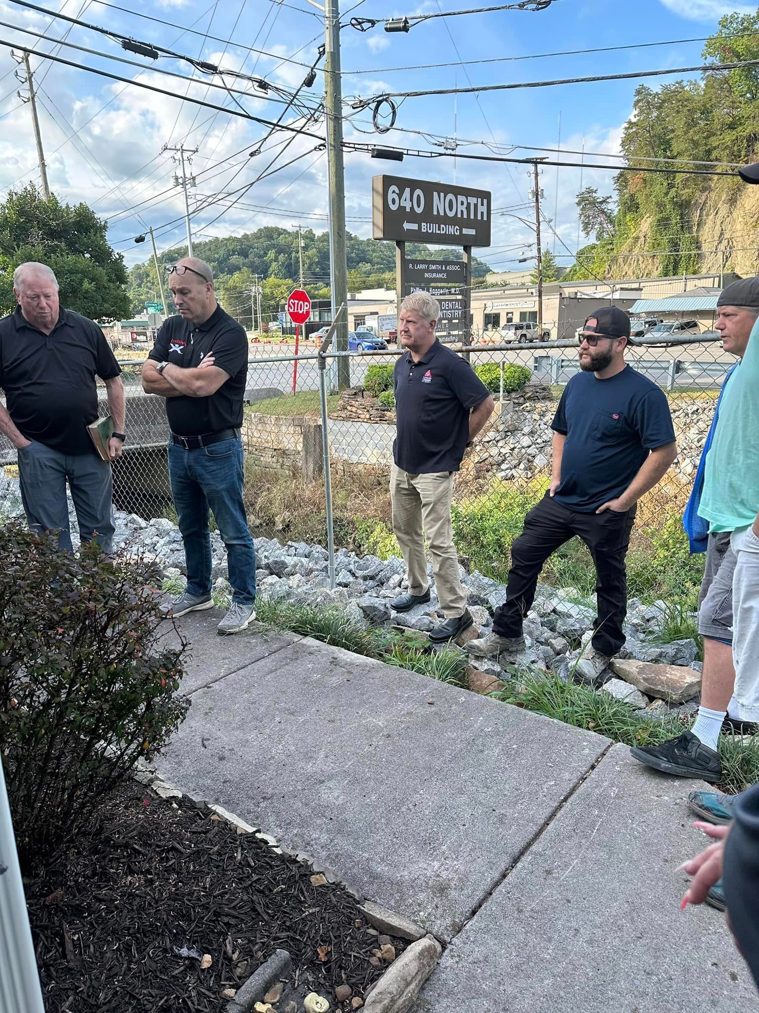A Group Of Men Are Standing On A Sidewalk | Knoxville, TN | Archie's