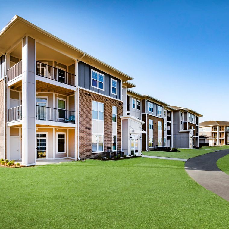 A large apartment building with lots of windows and balconies at Flats at Stones Crossing.