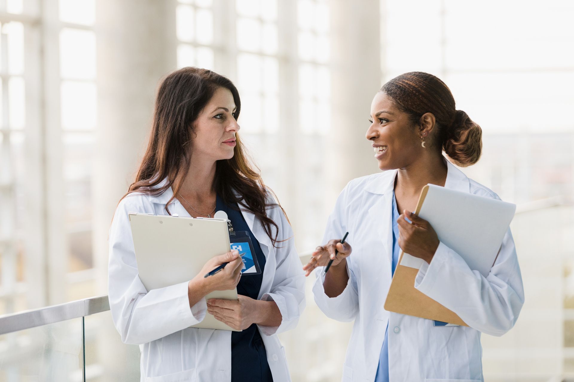 two female doctors are talking to each other in a hospital .