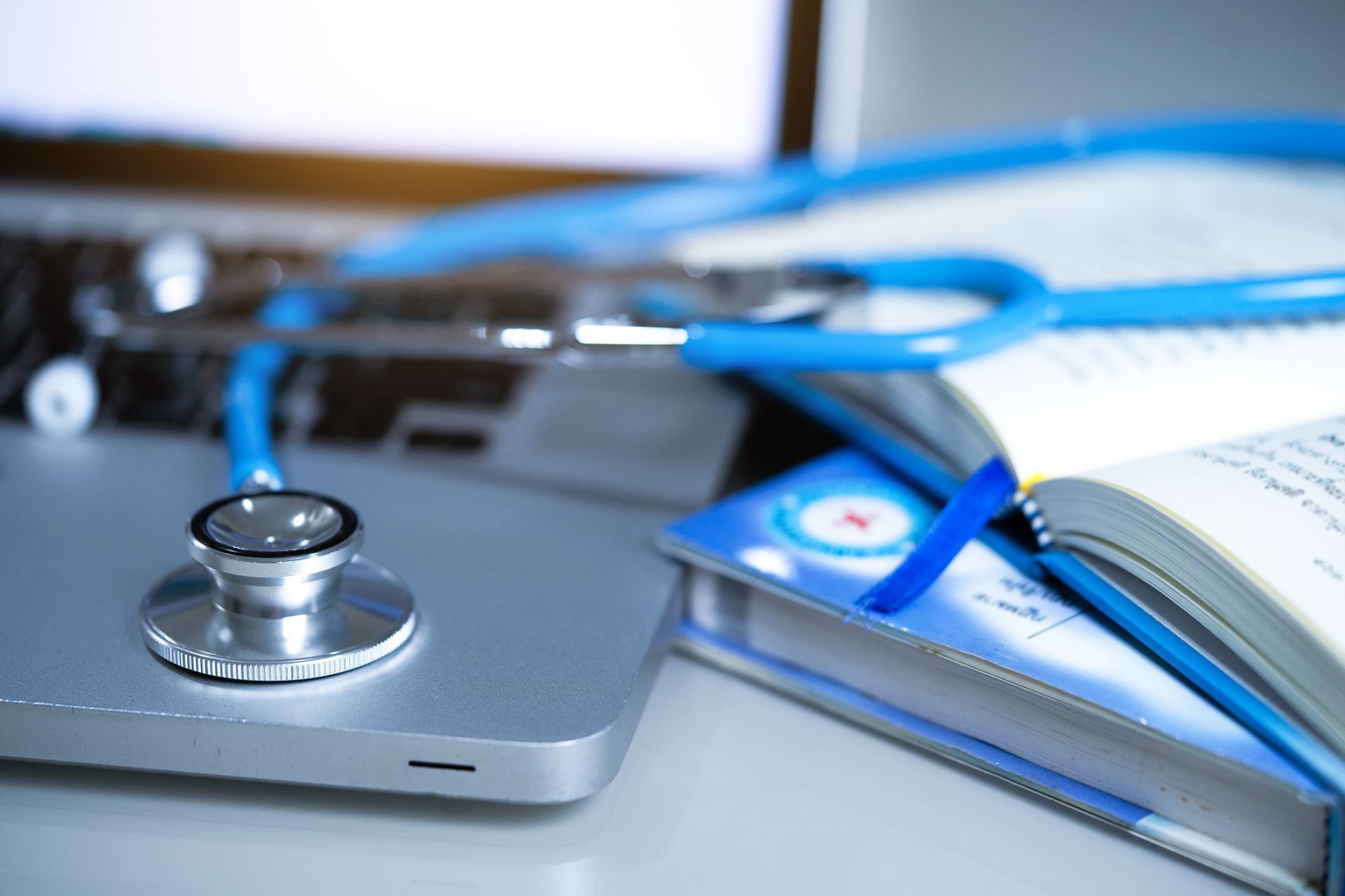 a stethoscope is sitting on top of a laptop next to a book .