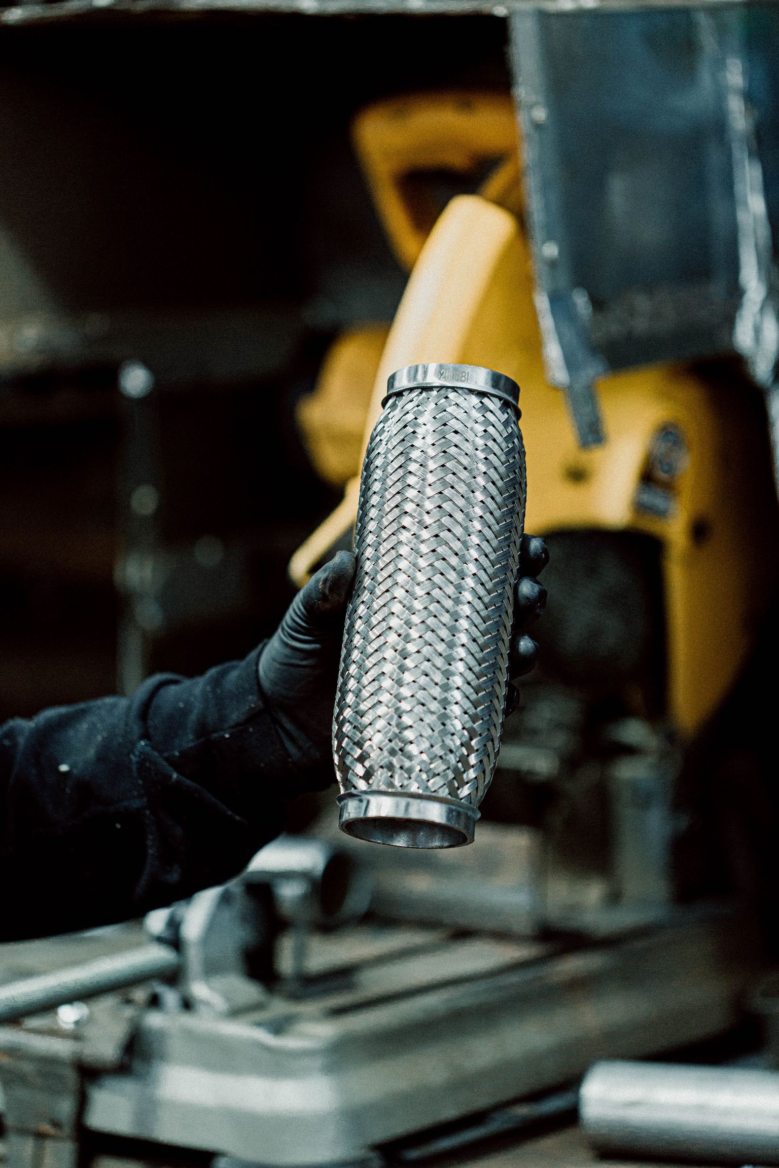 A person is holding a metal pipe in their hand in a garage.