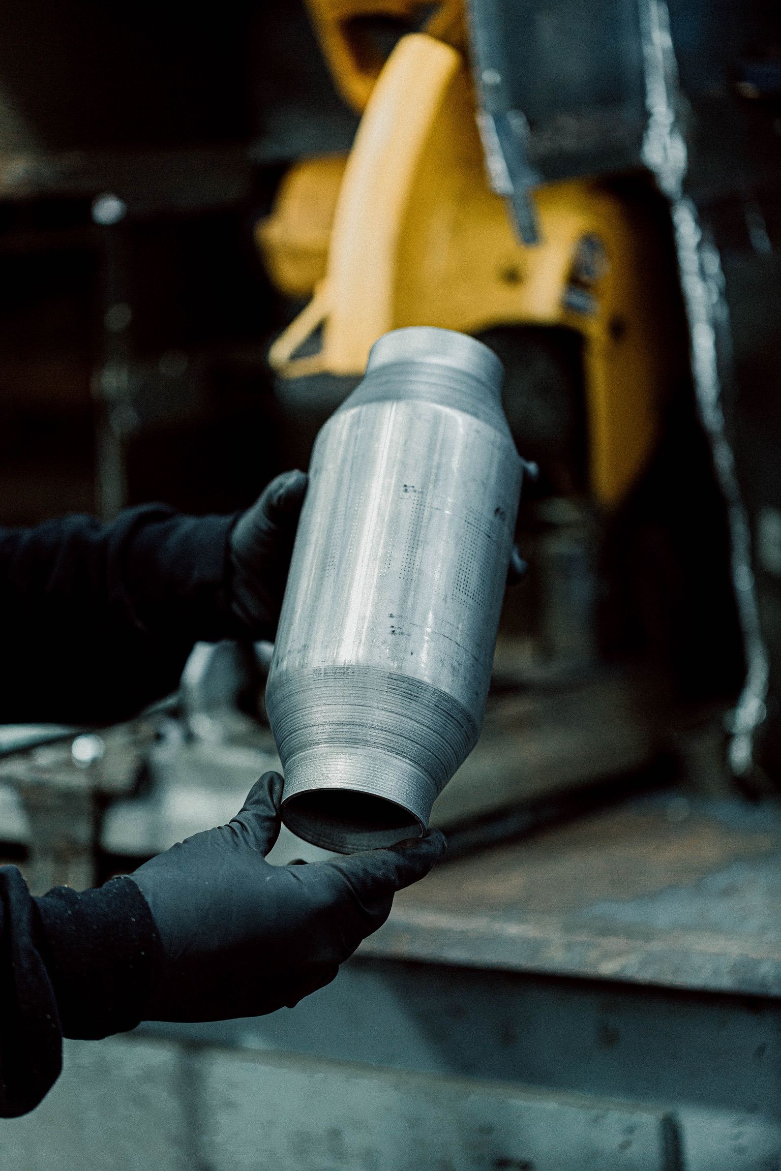 A person is holding a metal object in their hands.