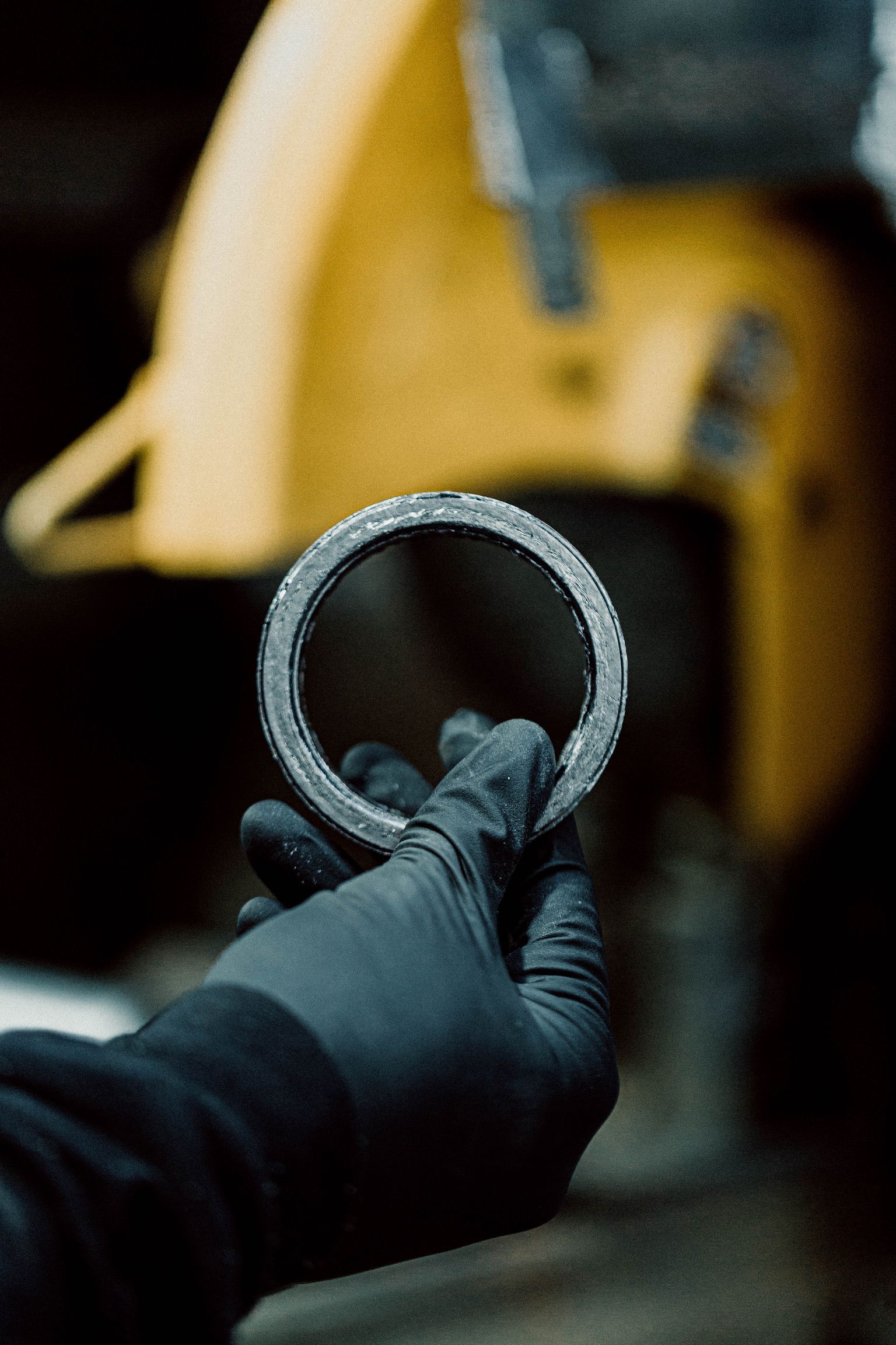 Une personne portant des gants noirs tient un anneau en métal dans sa main.