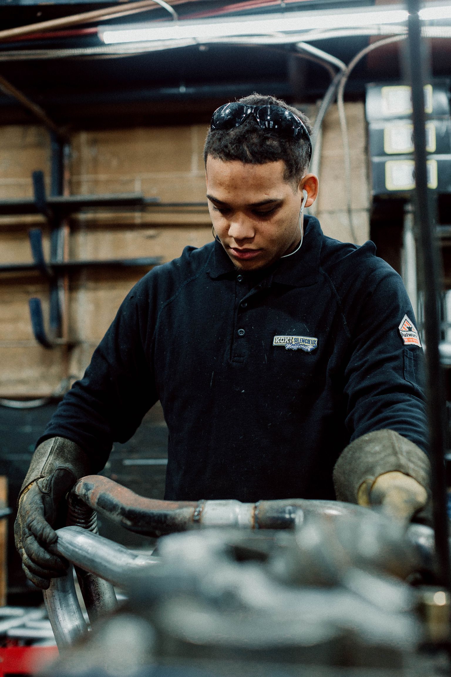 A man is working on a piece of metal in a garage.