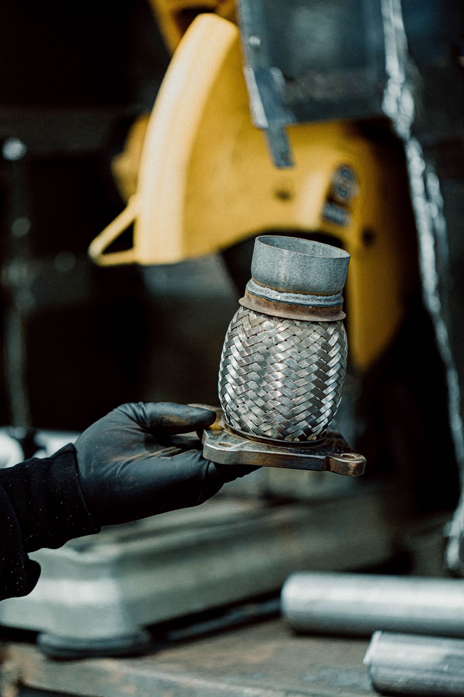 A person is holding a metal pipe in their hand in front of a machine.