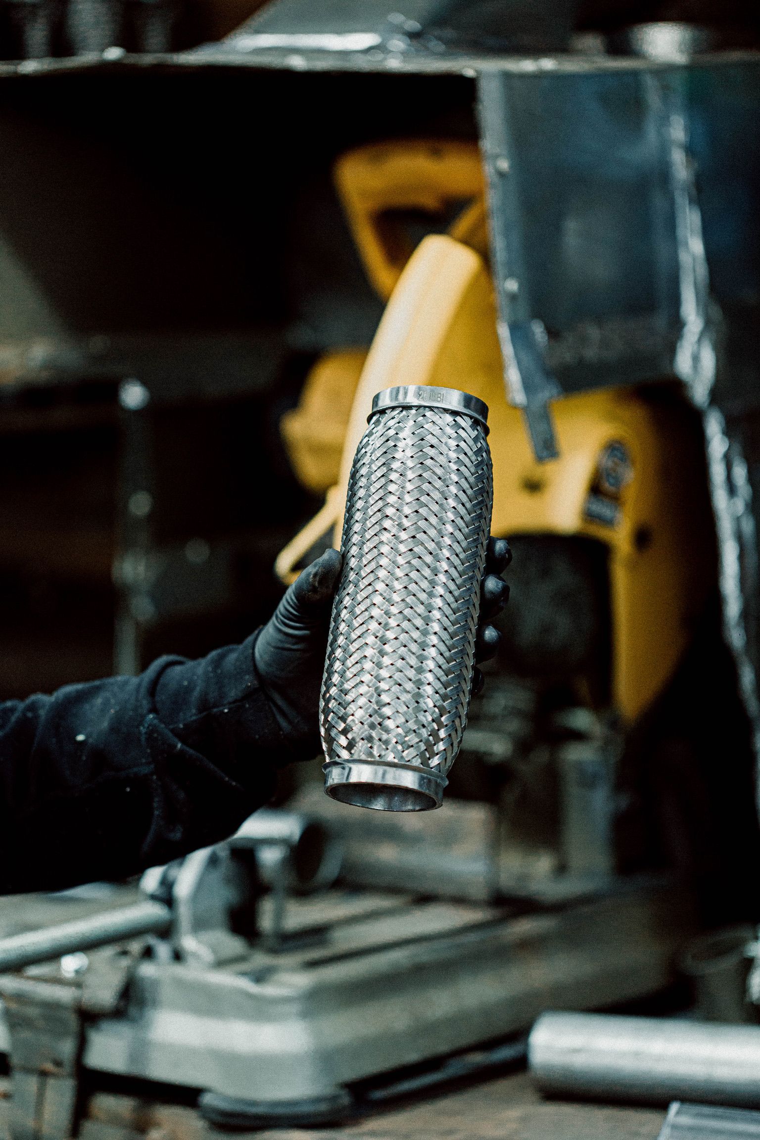 A person is holding a metal pipe in their hand in a garage.