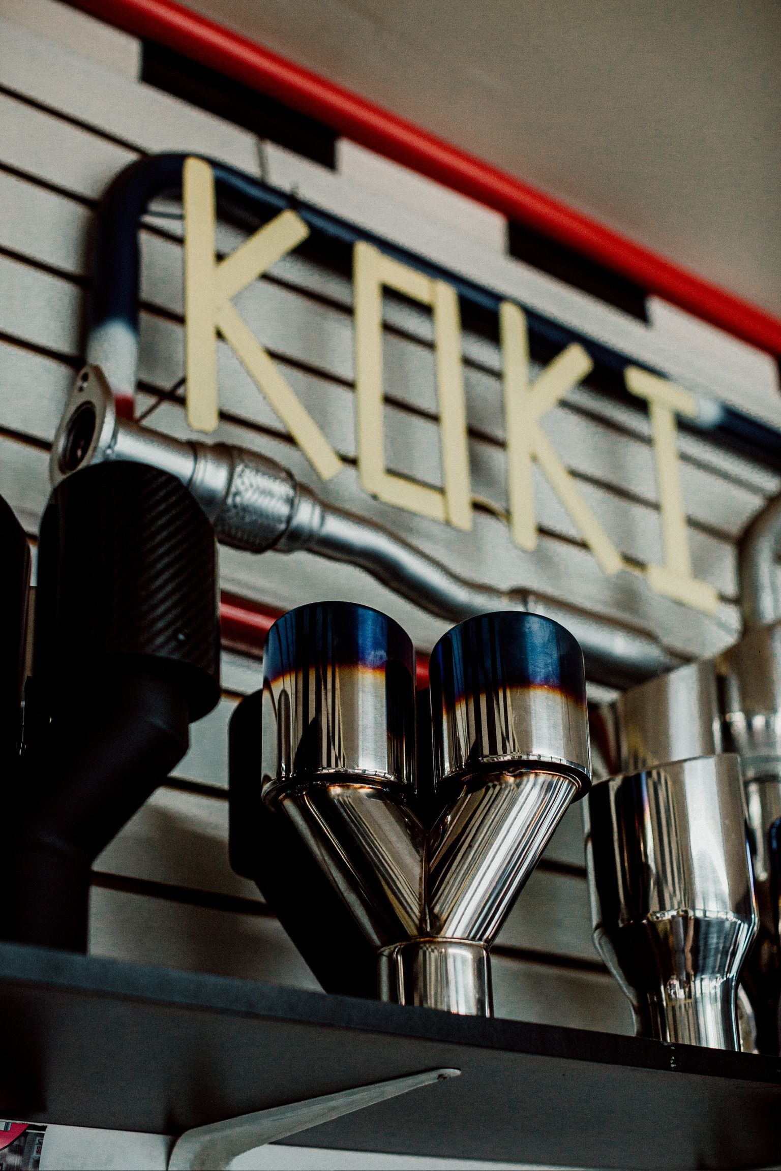 A display of exhaust pipes and a sign that says koki