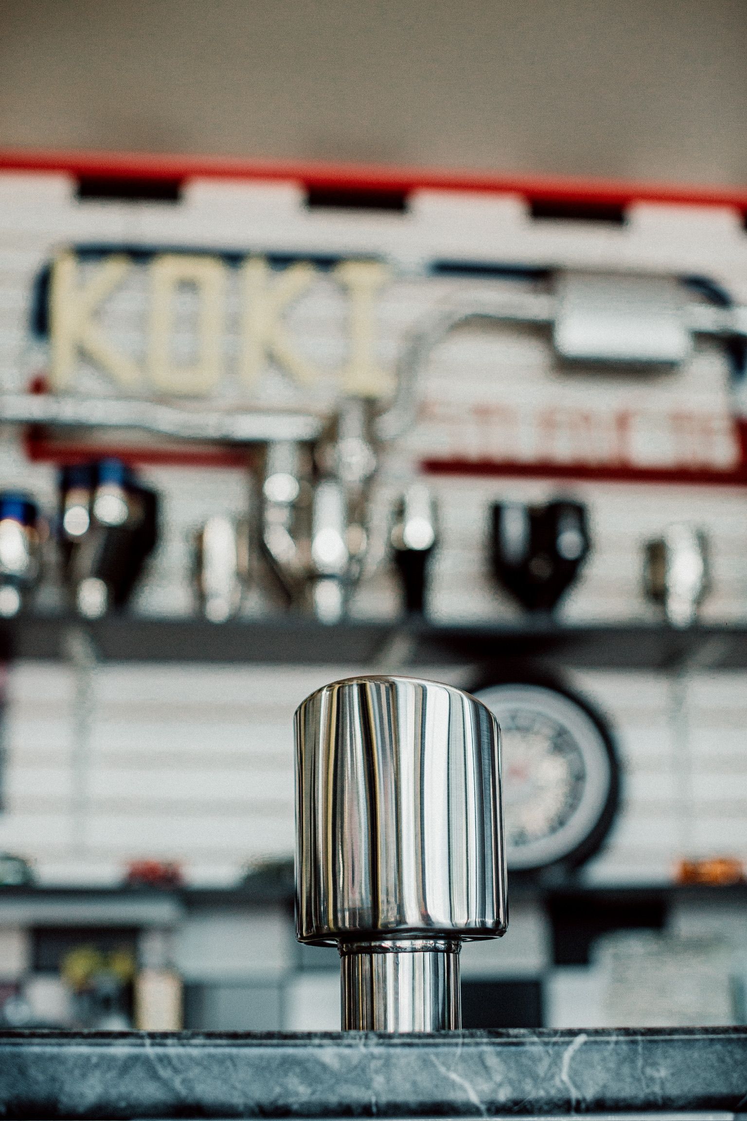 A stainless steel mug is sitting on a counter in a kitchen.