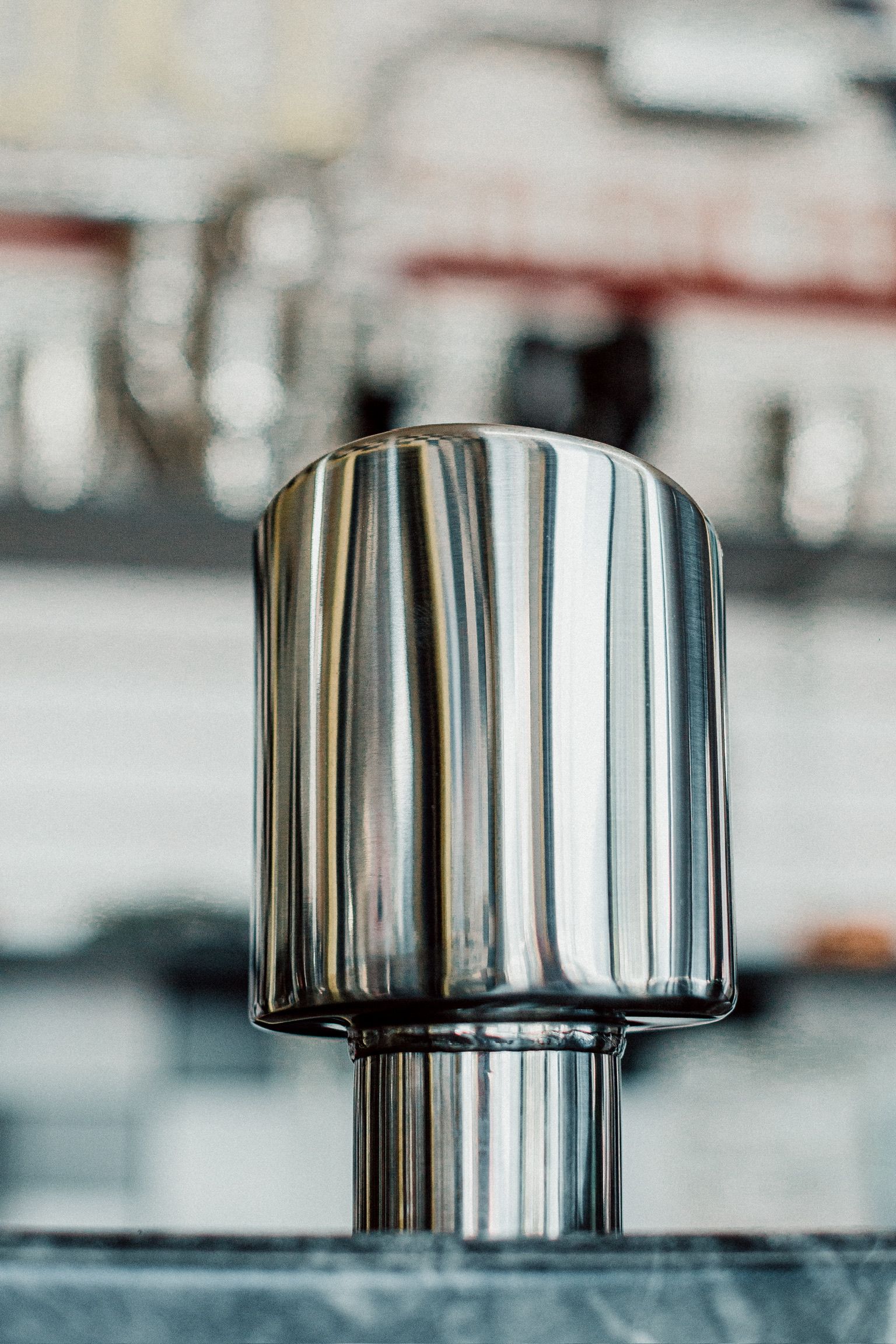 A close up of a stainless steel object on a table.