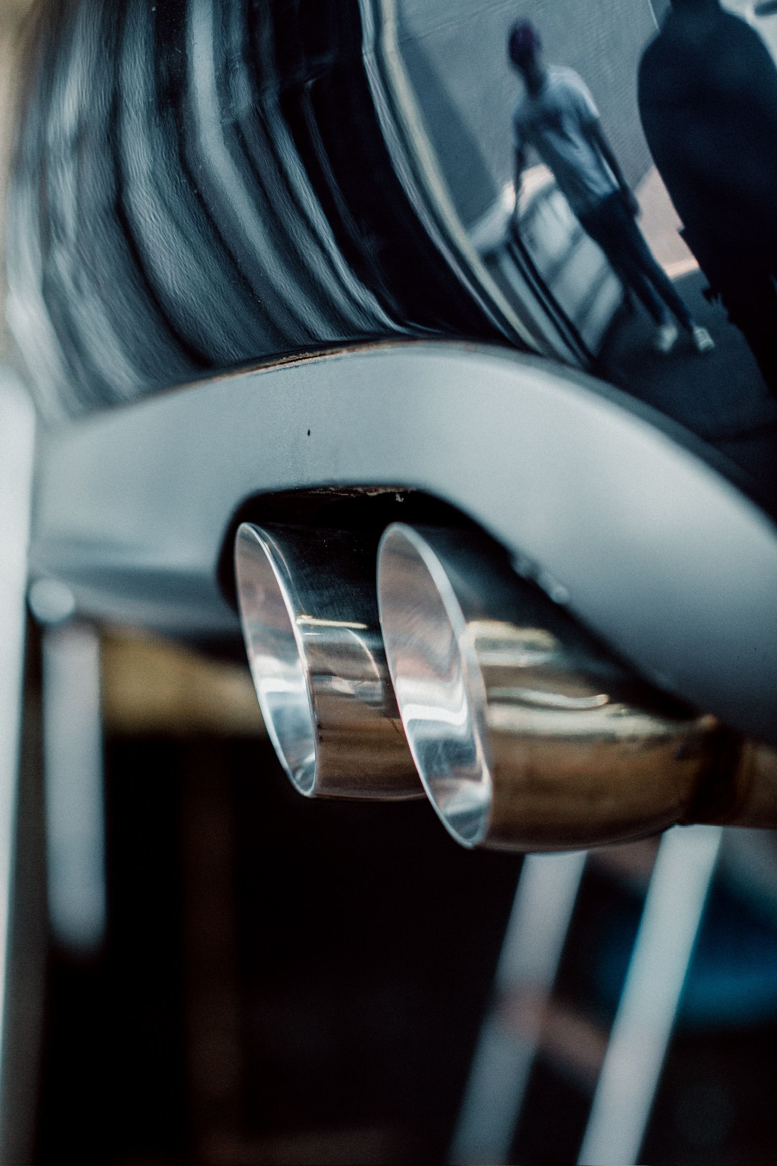 A close up of a car exhaust pipe in a garage.