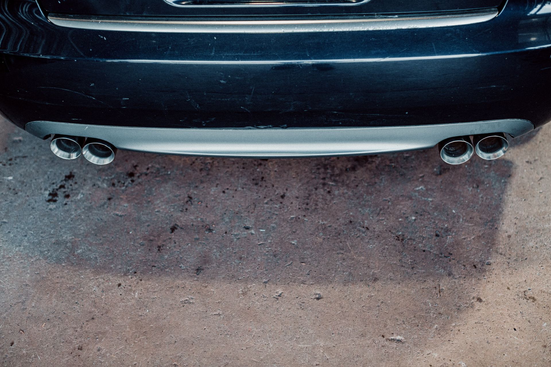 The exhaust pipes of a black car are visible