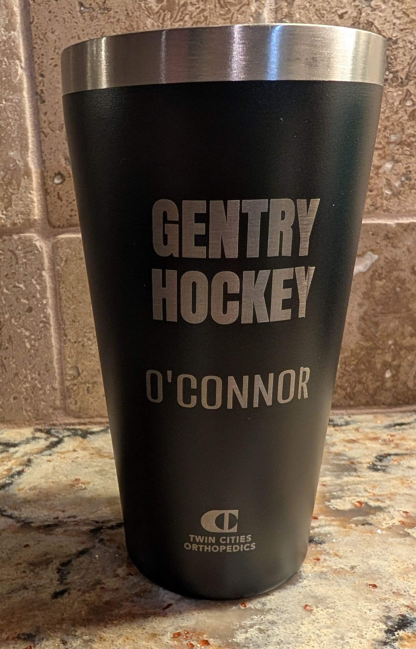 Black metal tumbler that has been laser etched.