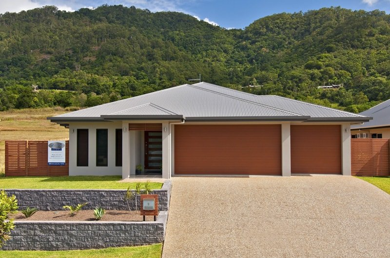 A House With A Gray Roof Is Surrounded By Mountains — Ashlee Jones Homes in Gordonvale, QLD
