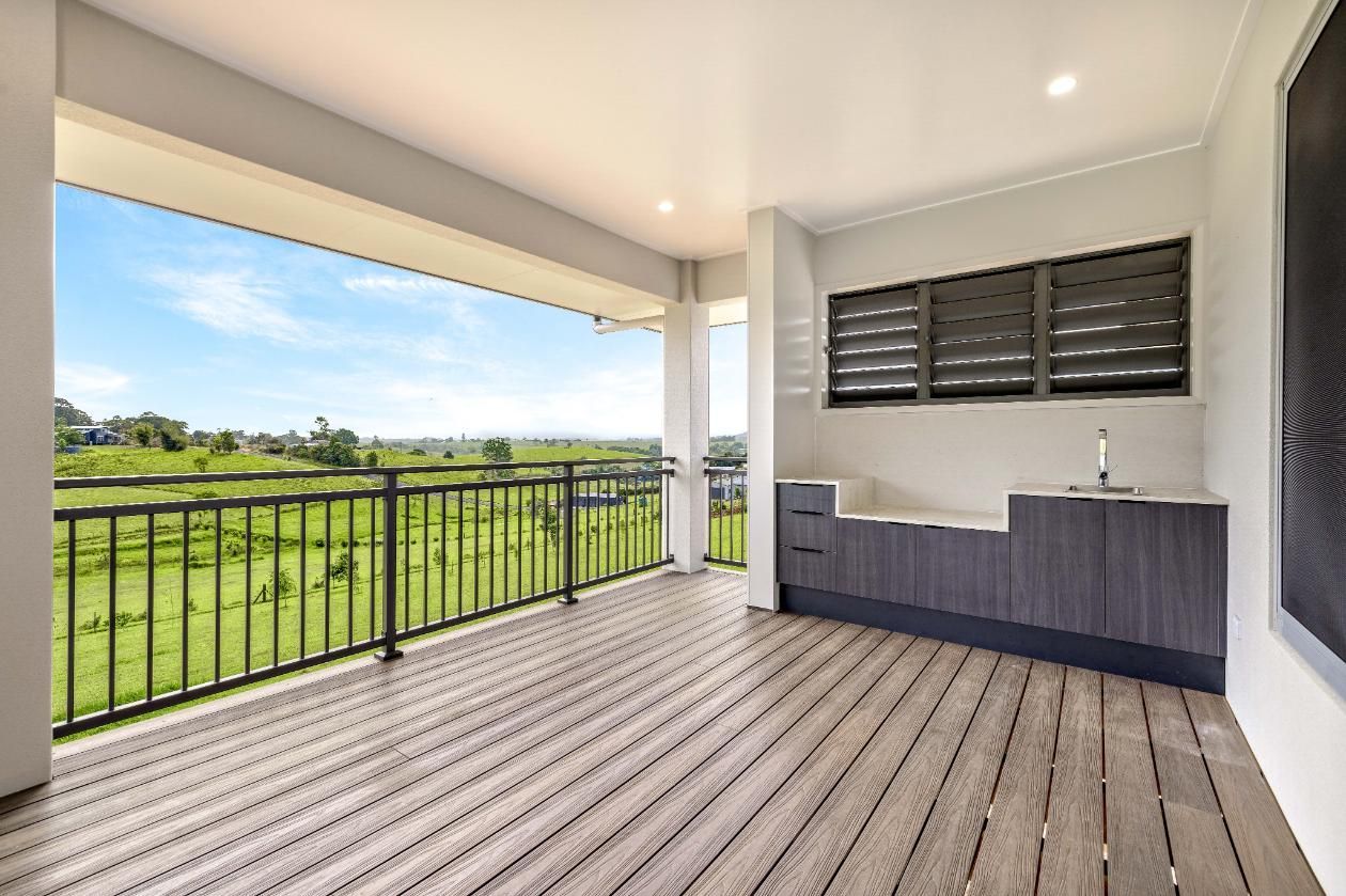 A large empty deck with a railing and a sink.