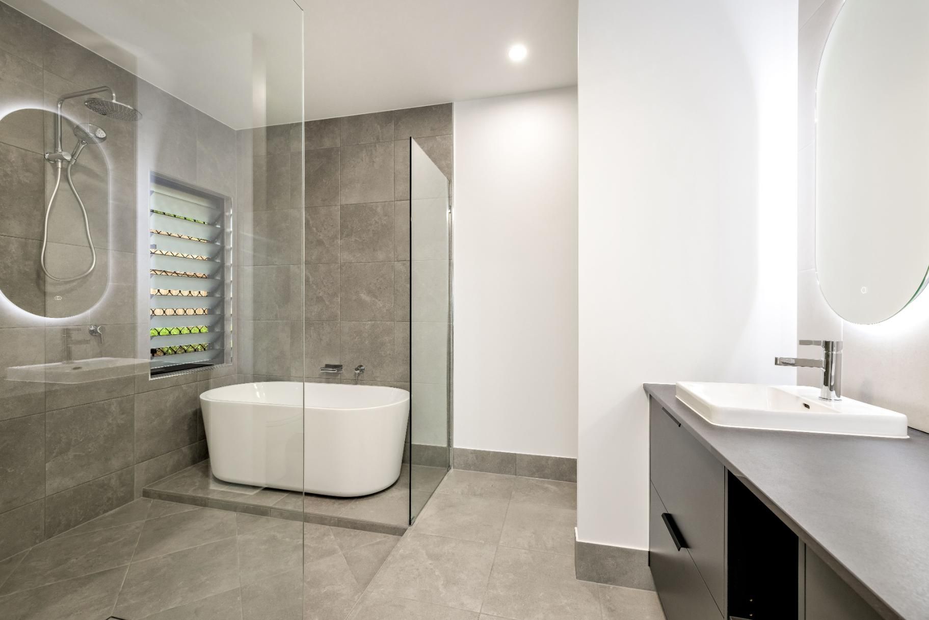 A Bathroom With a Bathtub, Sink, Mirror and Walk in Shower — Ashlee Jones Homes in Gordonvale, QLD