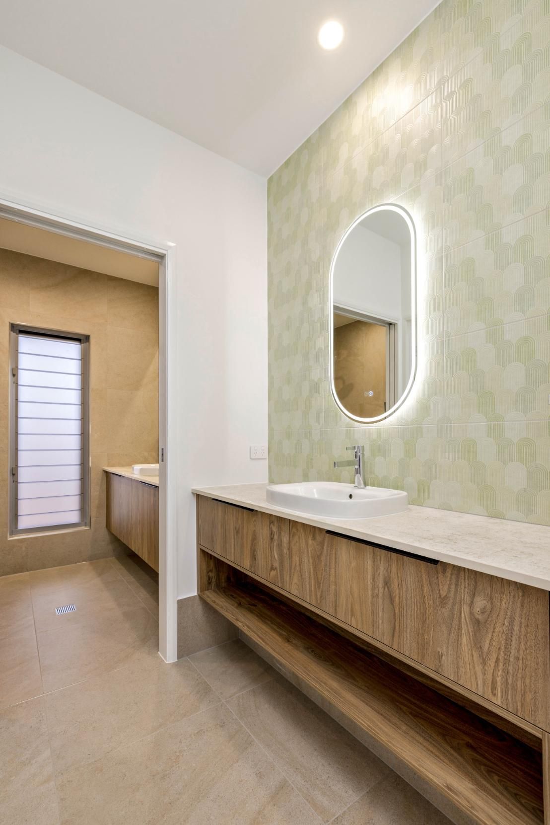 A Bathroom With a Sink, Mirror and Window — Ashlee Jones Homes in Gordonvale, QLD