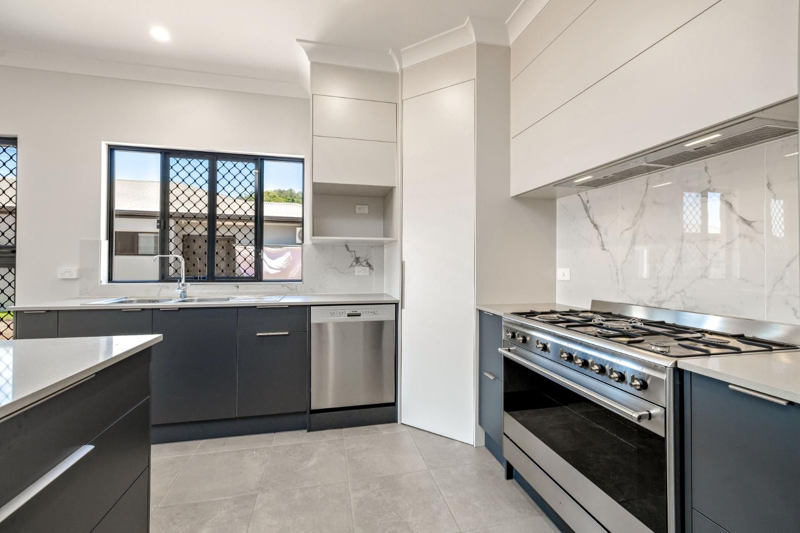A Kitchen With a Stove, Sink, and Dishwasher — Ashlee Jones Homes in Gordonvale, QLD