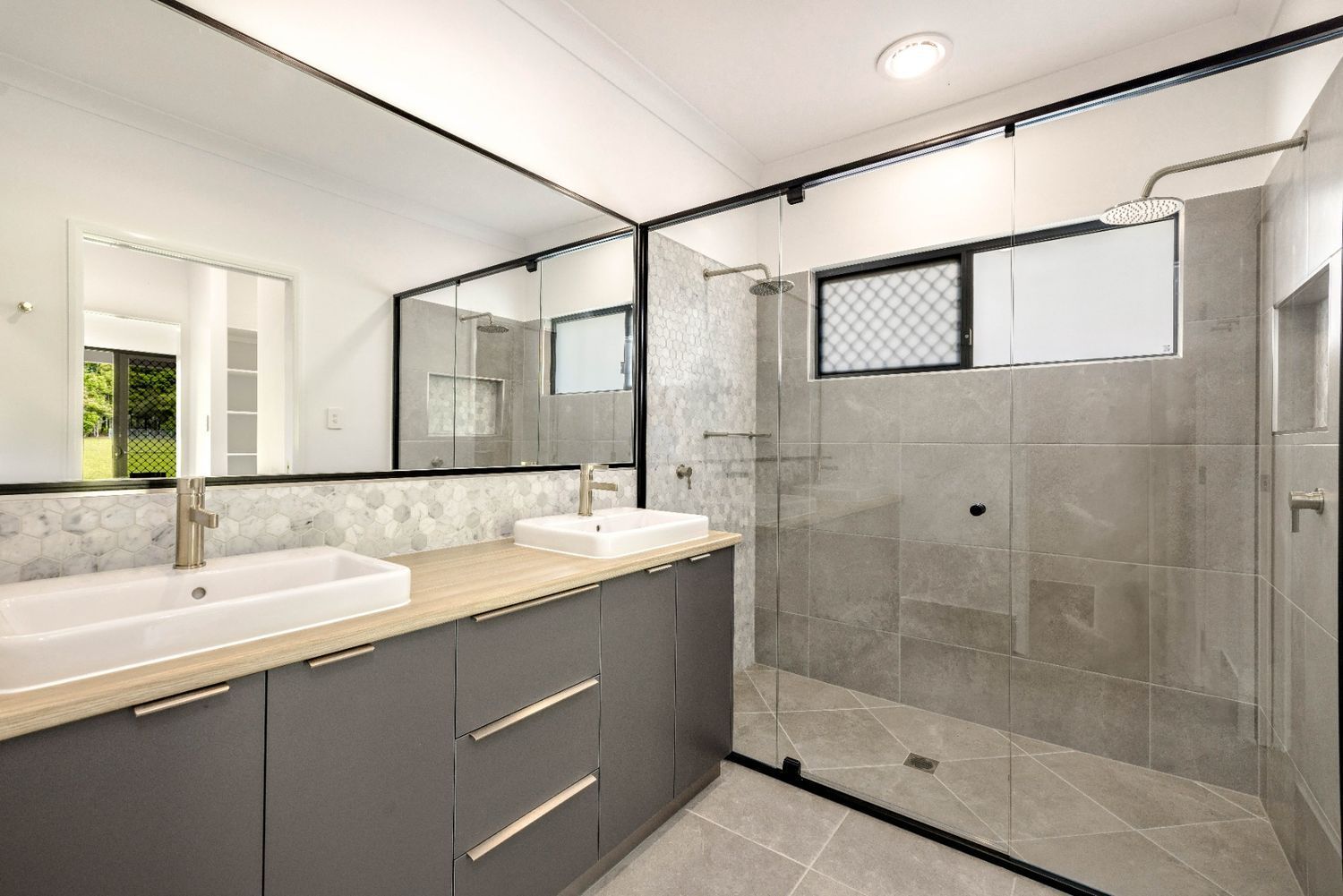 A Bathroom With Two Sinks and a Walk in Shower — Ashlee Jones Homes in Gordonvale, QLD