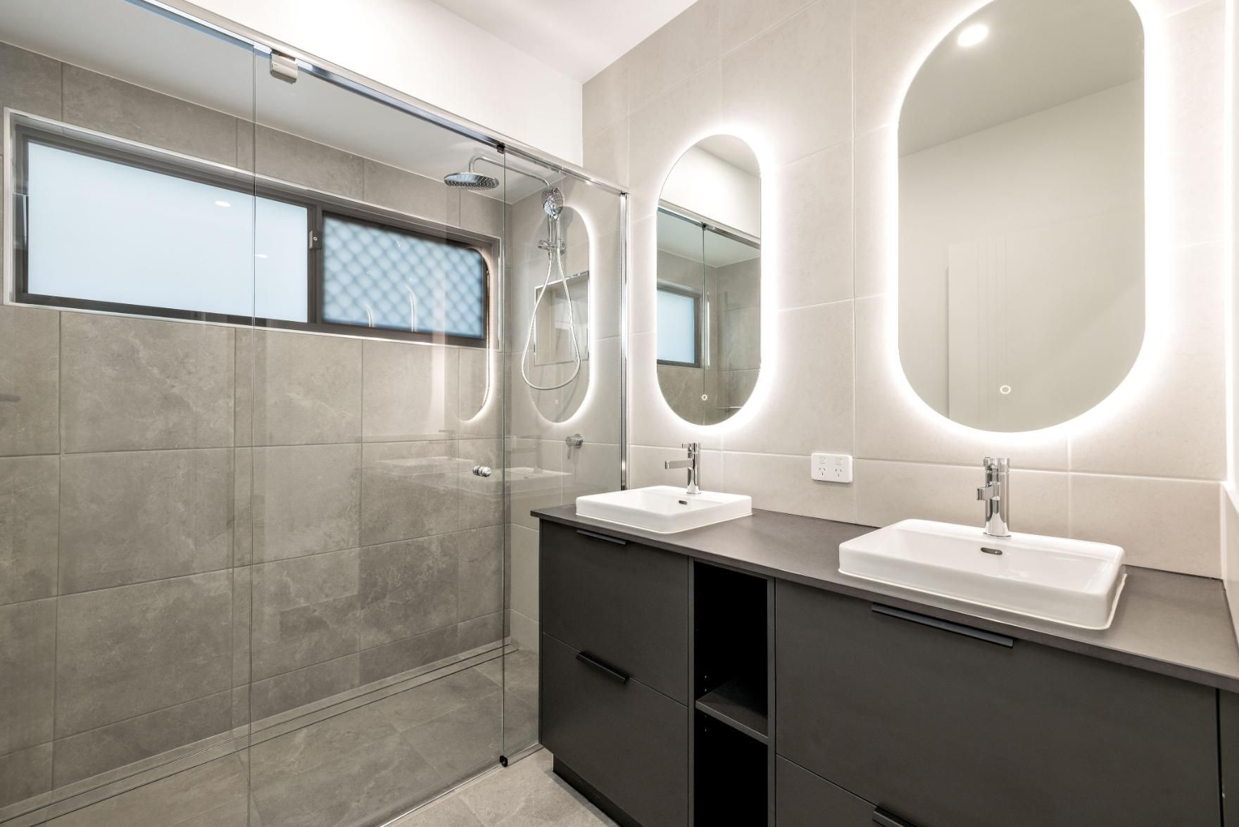 A Bathroom With Two Sinks, a Shower and Two Mirrors — Ashlee Jones Homes in Gordonvale, QLD
