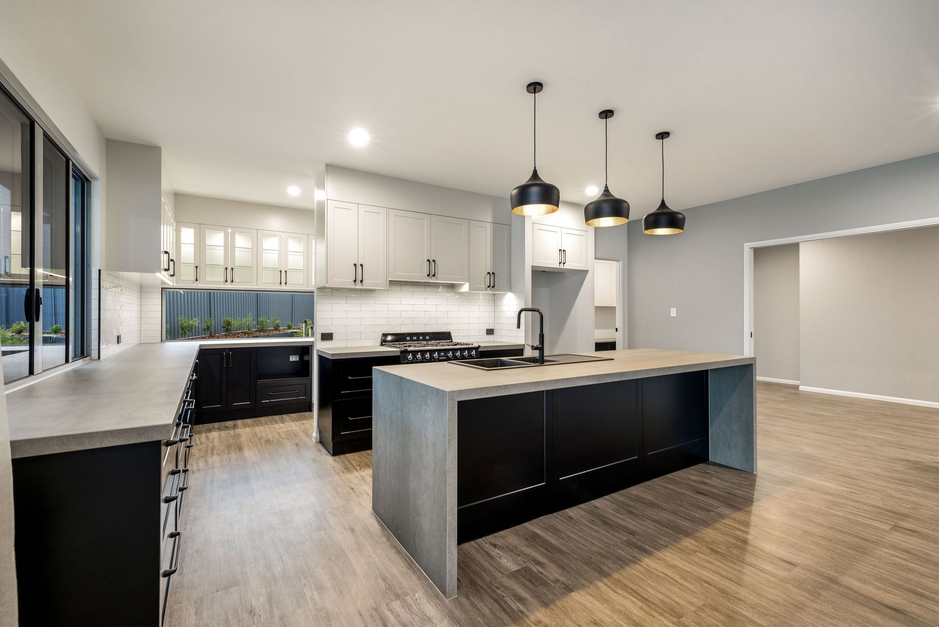 An Empty Room With Sliding Glass Doors and a Ceiling Fan — Ashlee Jones Homes in Gordonvale, QLD