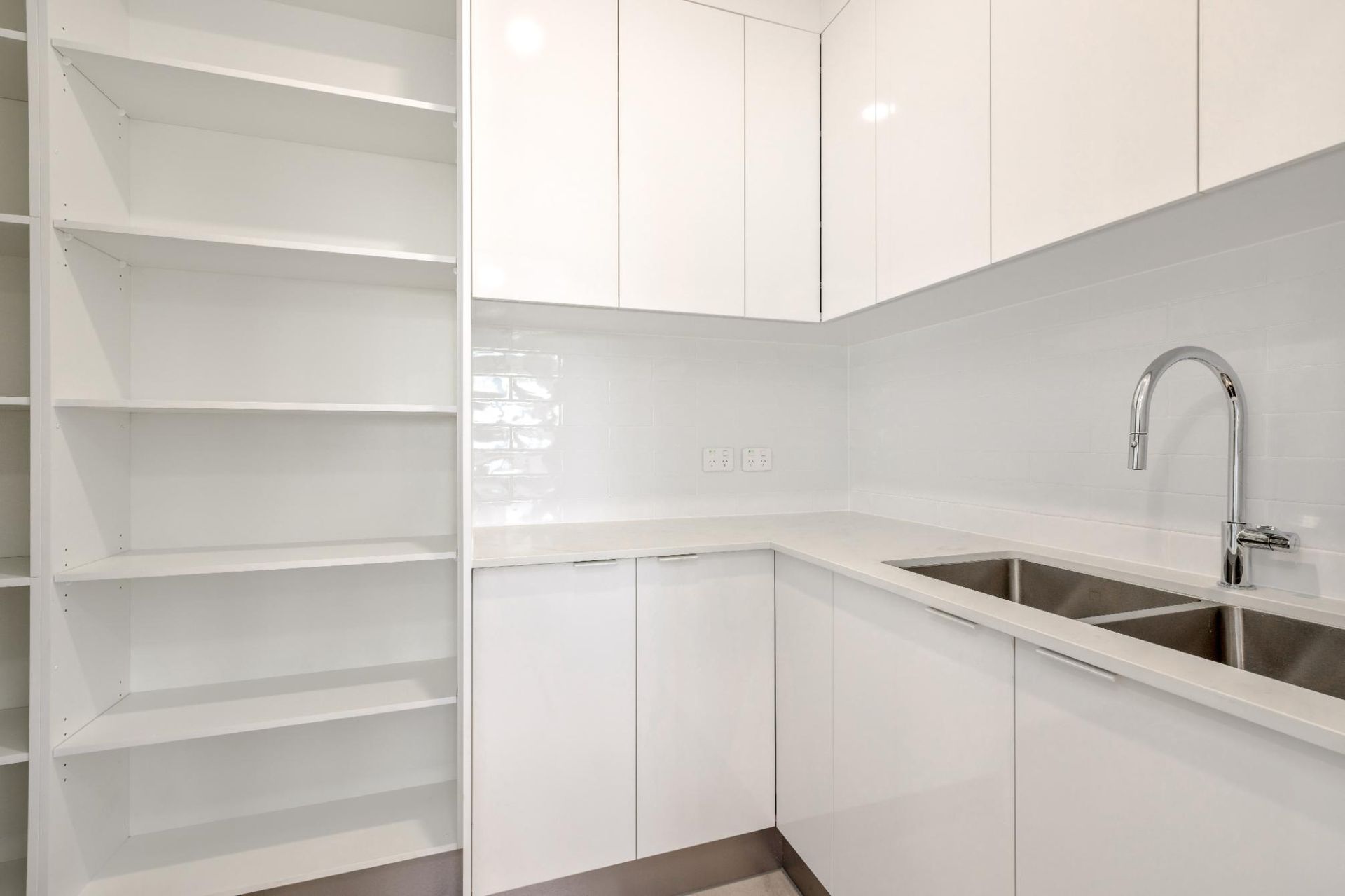 A Kitchen With White Cabinets, a Sink, and Shelves — Ashlee Jones Homes in Gordonvale, QLD
