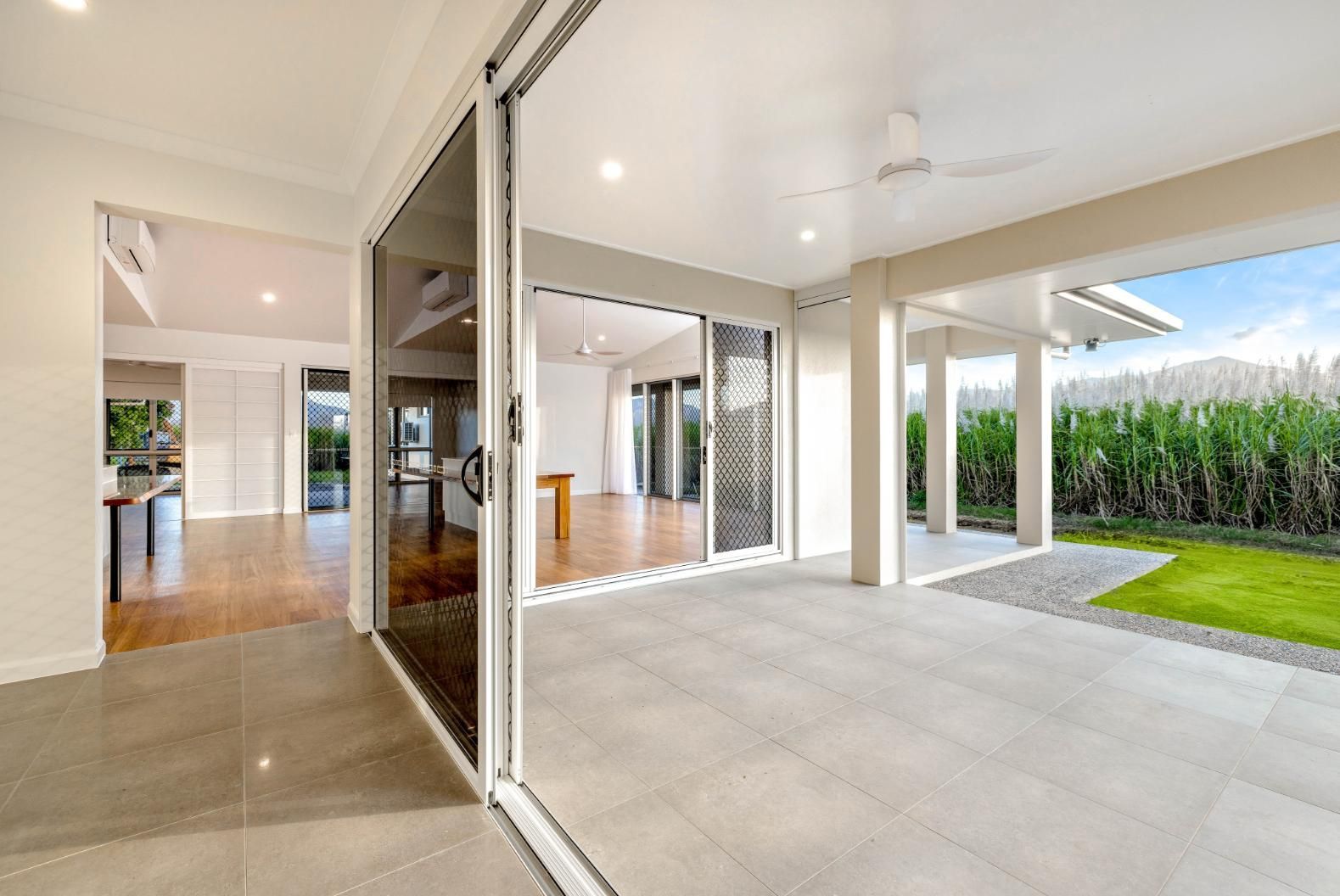An Empty House With Sliding Glass Doors Leading to a Patio — Ashlee Jones Homes in Gordonvale, QLD