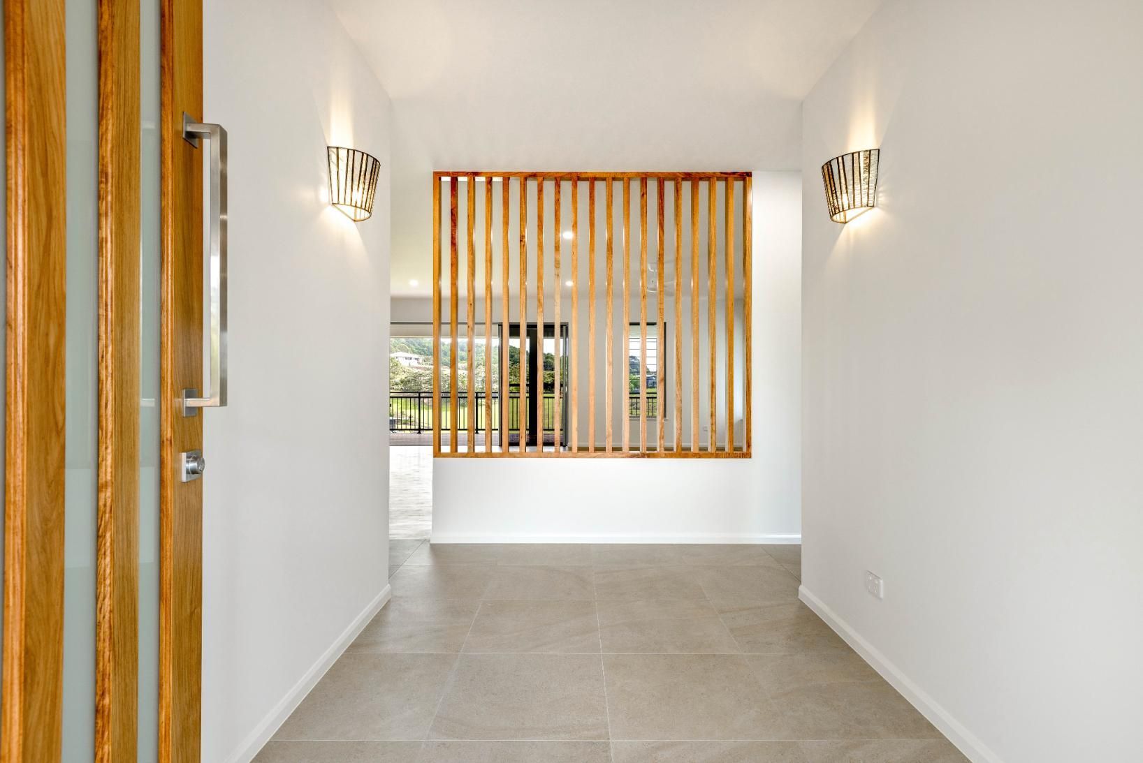An Empty Hallway With a Wooden Divider and a Window — Ashlee Jones Homes in Gordonvale, QLD