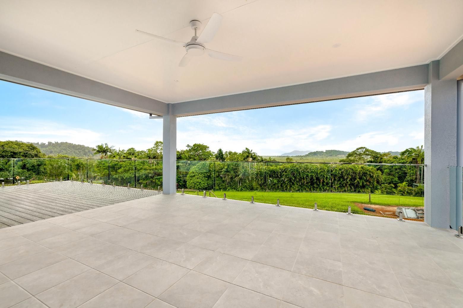 An Empty Patio With a Ceiling Fan and a View of a Field — Ashlee Jones Homes in Gordonvale, QLD