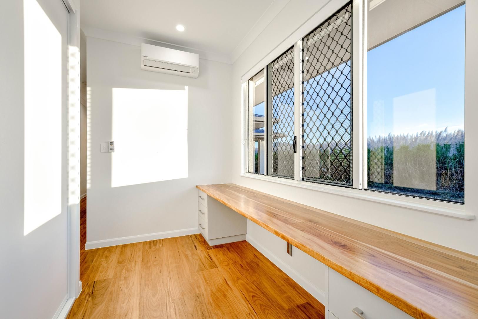 A Room With a Long Wooden Desk and a Lot of Windows — Ashlee Jones Homes in Gordonvale, QLD