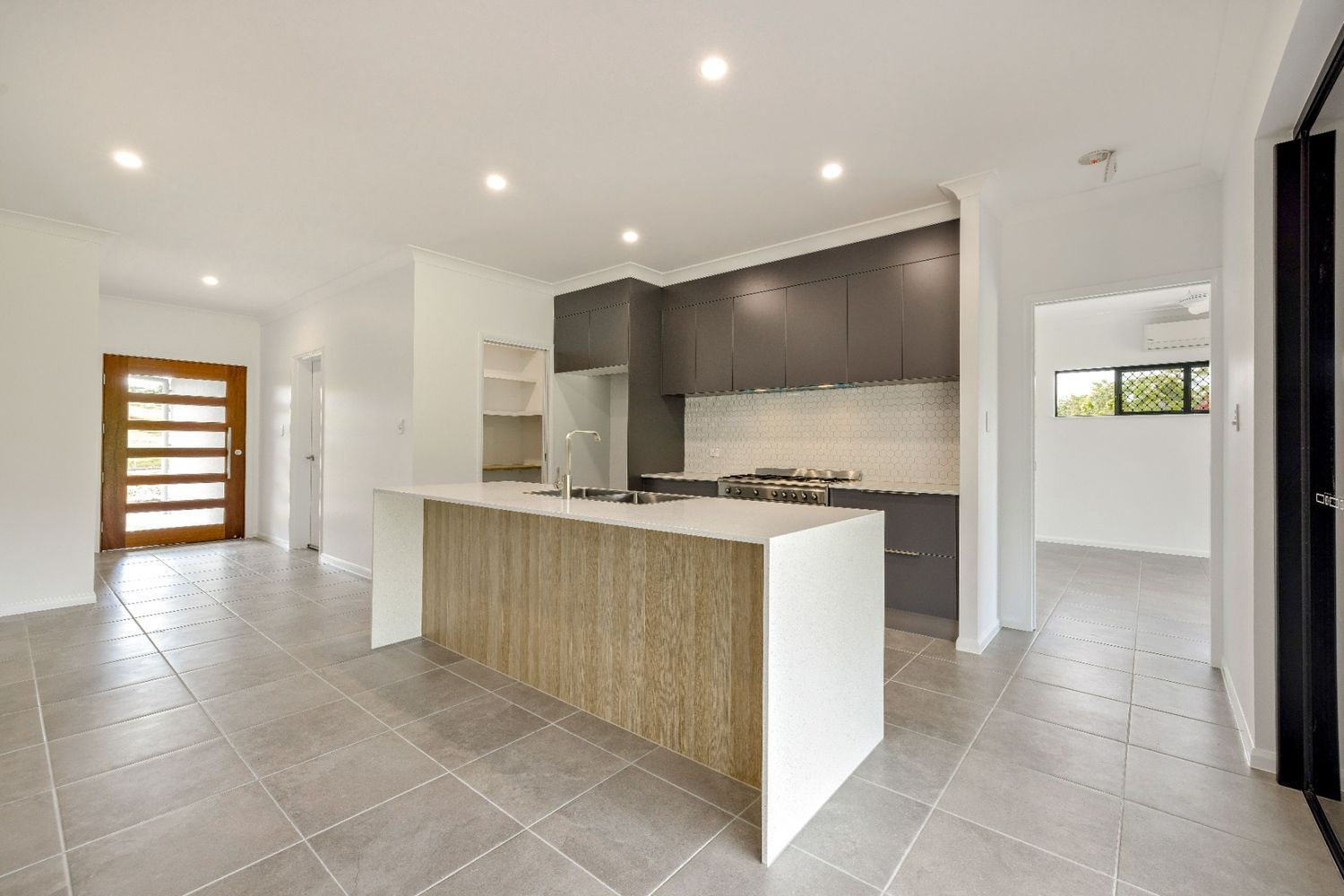 A Kitchen With a Large Island in the Middle of the Room — Ashlee Jones Homes in Gordonvale, QLD