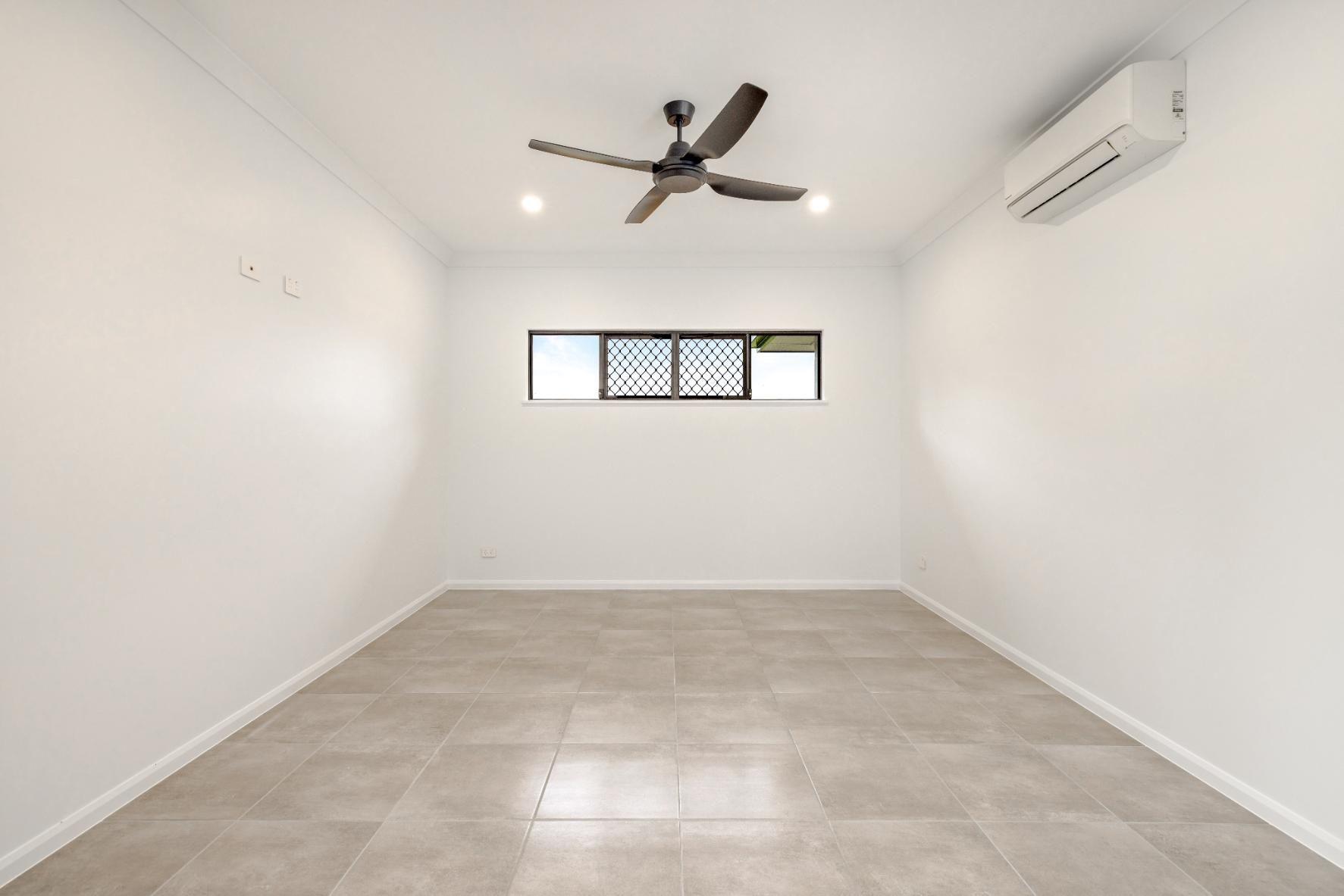 An Empty Room With a Ceiling Fan and a Window — Ashlee Jones Homes in Gordonvale, QLD