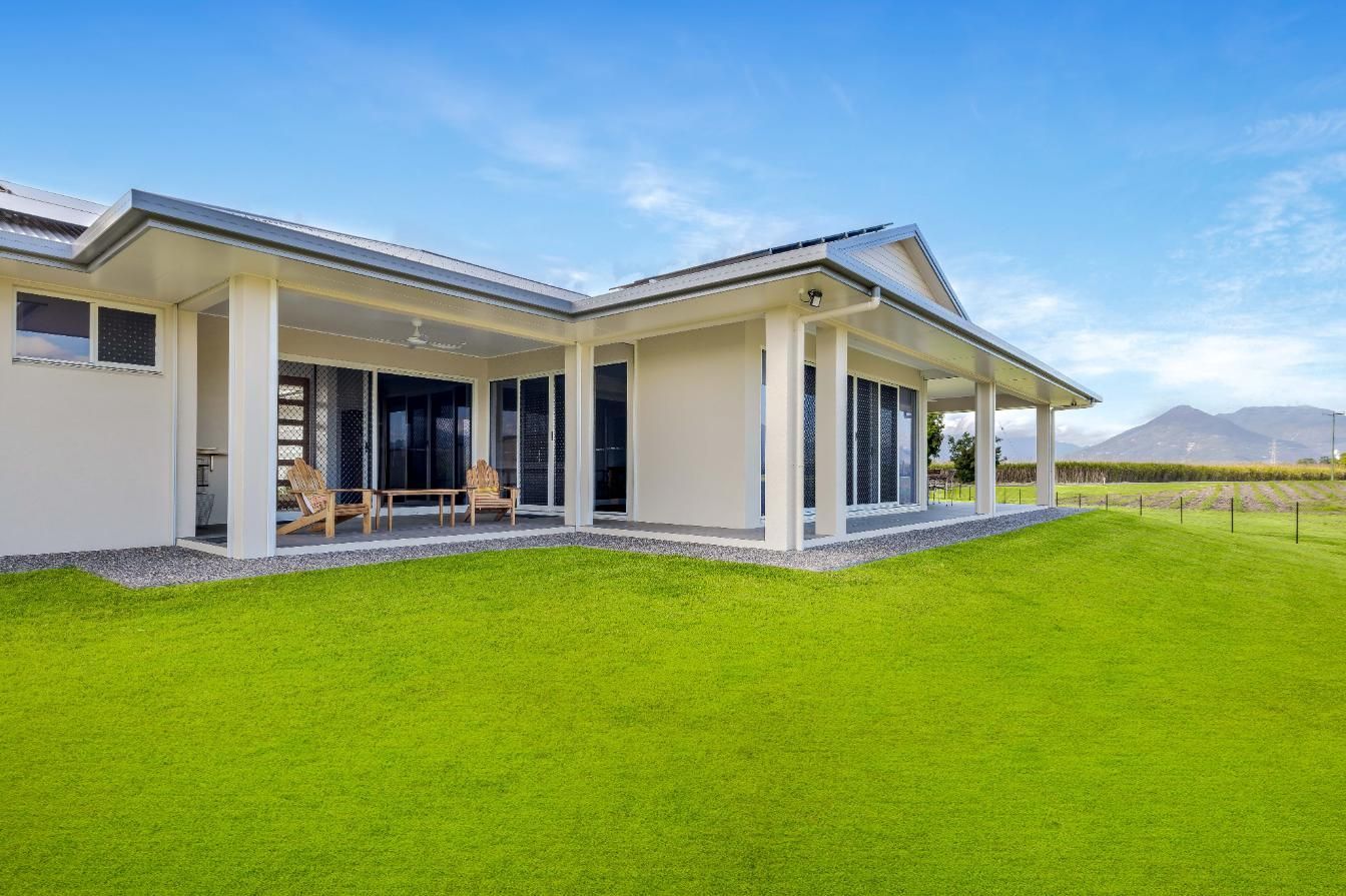 A White House With a Large Lawn in Front of It — Ashlee Jones Homes in Gordonvale, QLD