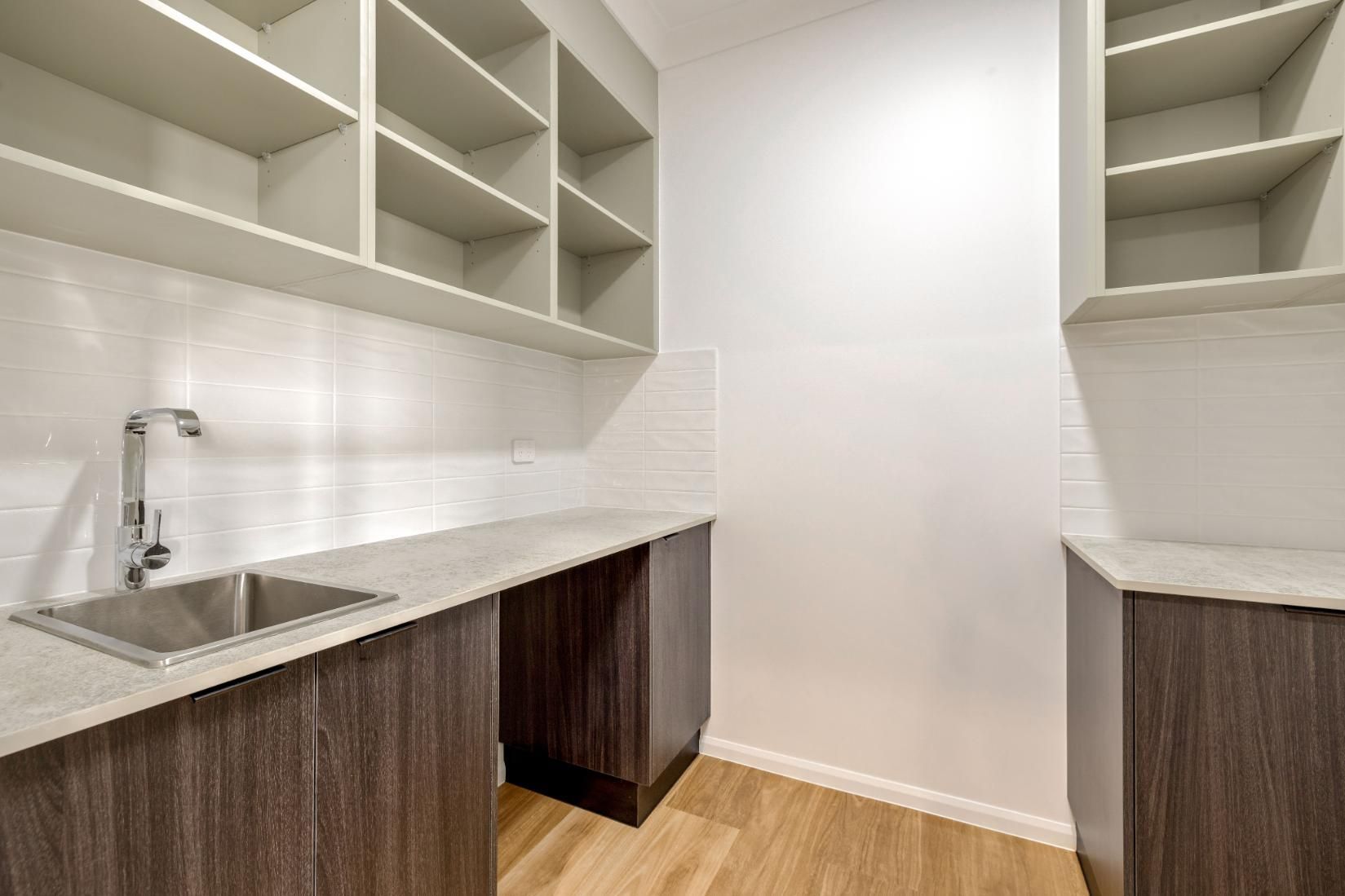 A Kitchen With a Sink, Cabinets and Shelves — Ashlee Jones Homes in Gordonvale, QLD