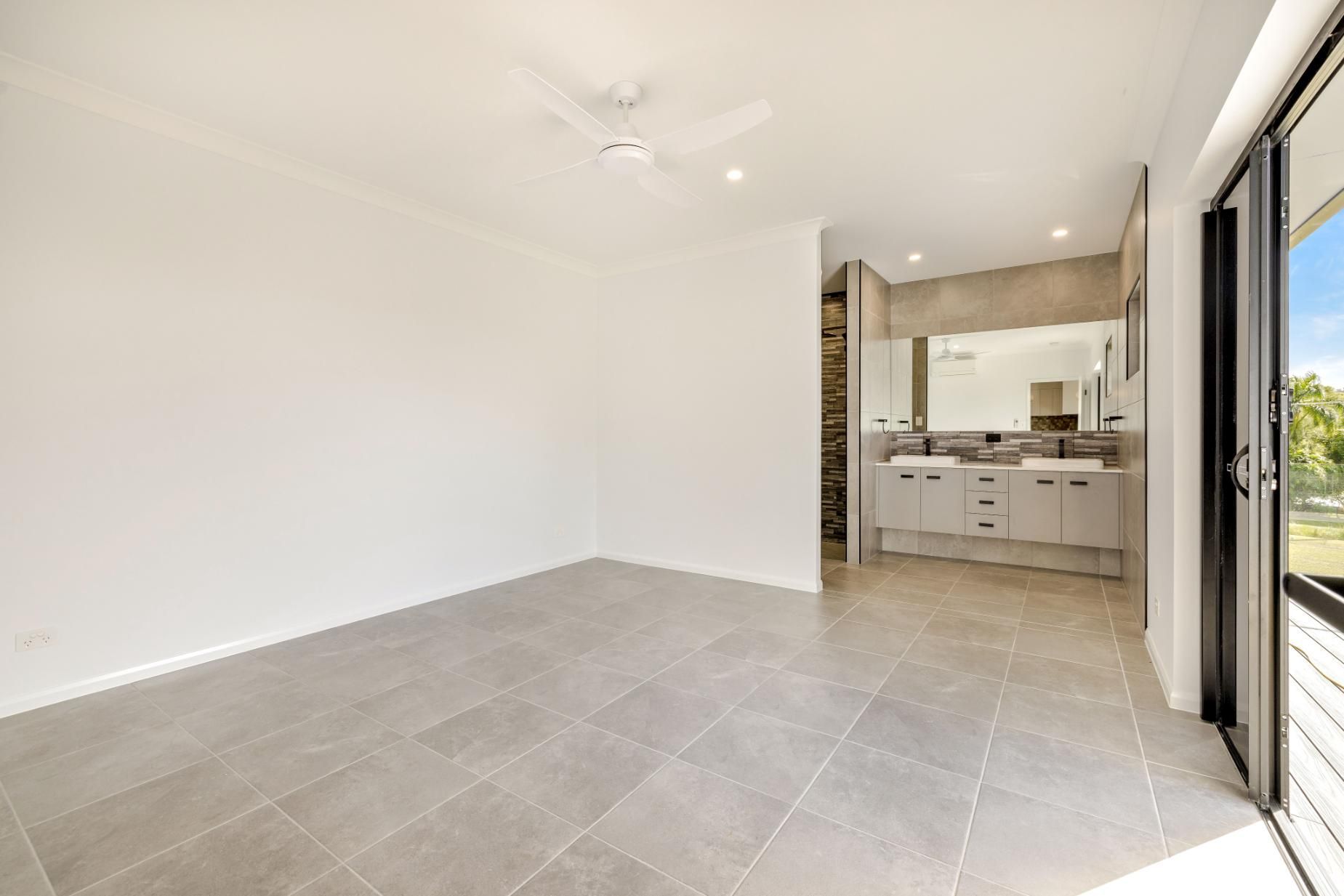 An Empty Room With Two Sinks and a Ceiling Fan — Ashlee Jones Homes in Gordonvale, QLD