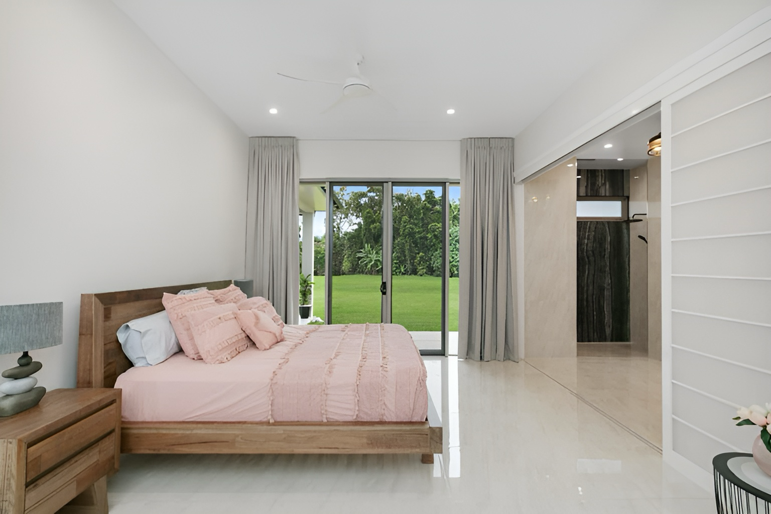 A Bedroom With a Large Bed and a Sliding Glass Door — Ashlee Jones Homes in Gordonvale, QLD