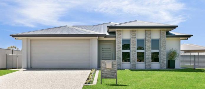 A White House With a Garage and a Sign in Front of It — Ashlee Jones Homes in Gordonvale, QLD