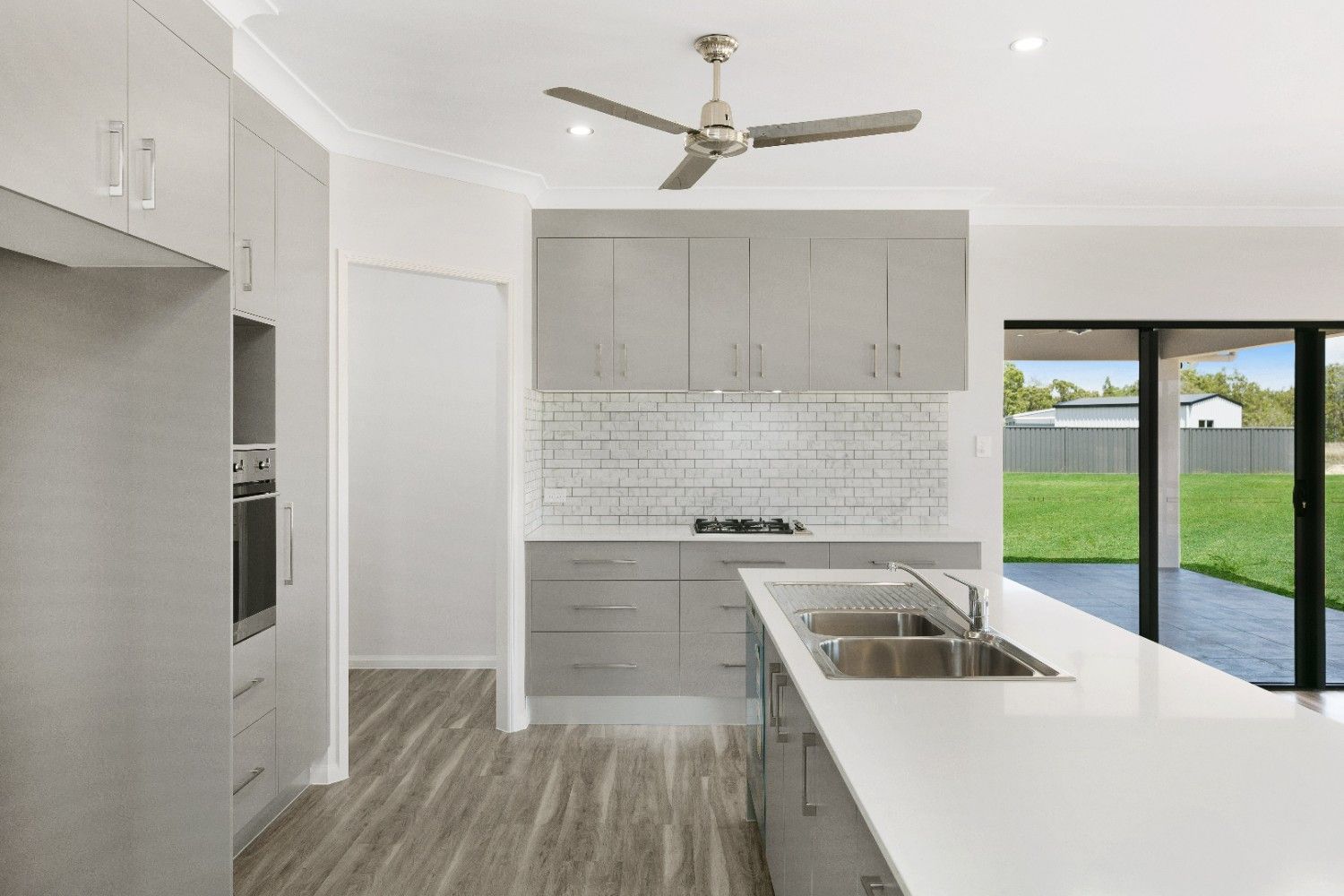 A Kitchen With a Ceiling Fan and a Sink — Ashlee Jones Homes in Gordonvale, QLD