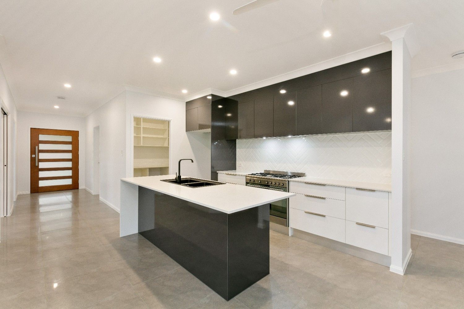 A Kitchen With a Large Island in the Middle of It — Ashlee Jones Homes in Gordonvale, QLD