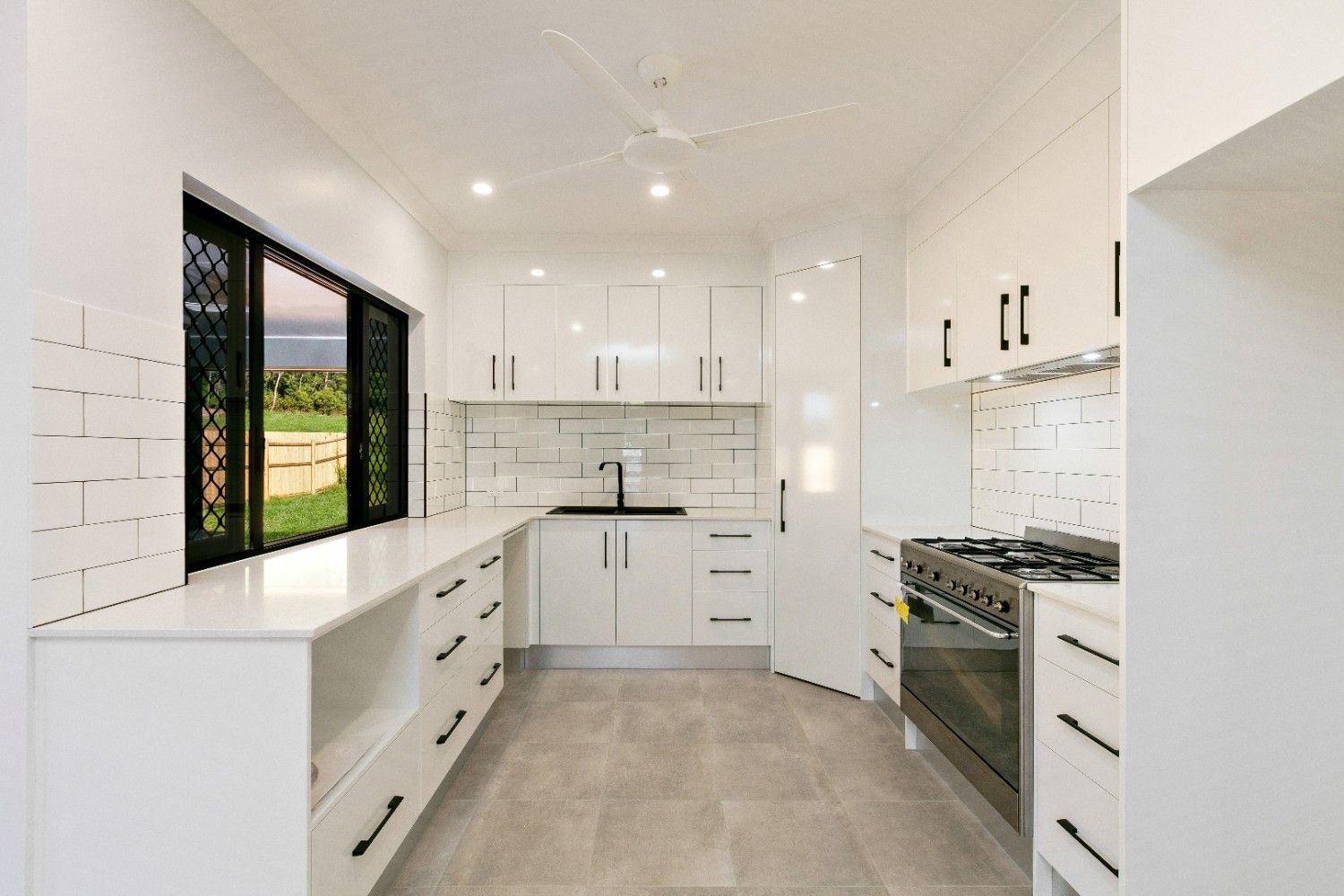 A Kitchen With White Cabinets and Stainless Steel Appliances  — Ashlee Jones Homes in Gordonvale, QLD