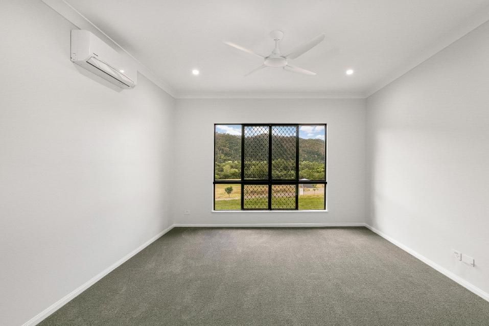 An Empty Room With a Large Window and a Ceiling Fan — Ashlee Jones Homes in Gordonvale, QLD