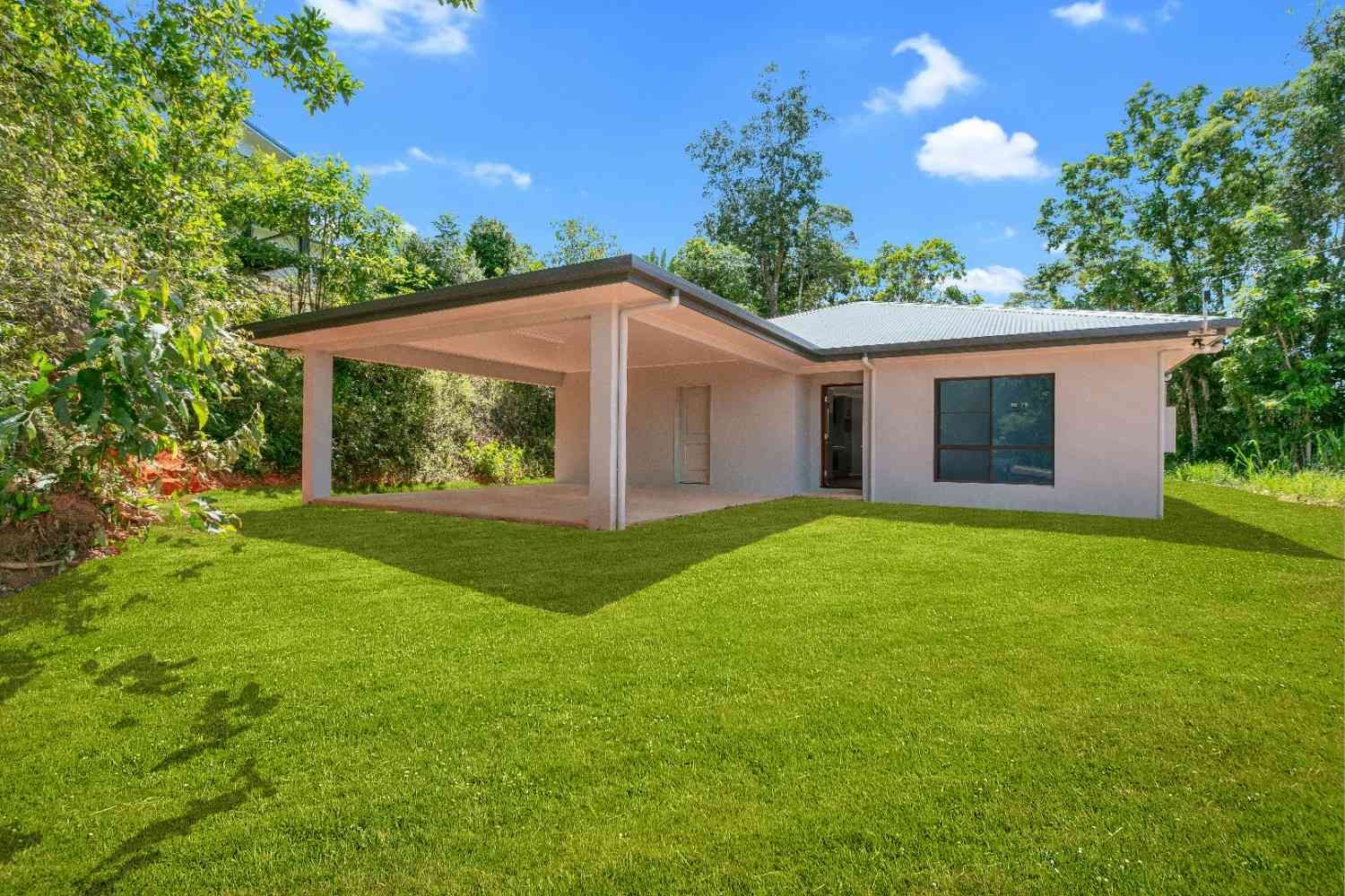 A White House With a Large Lawn in Front of It — Ashlee Jones Homes in Gordonvale, QLD