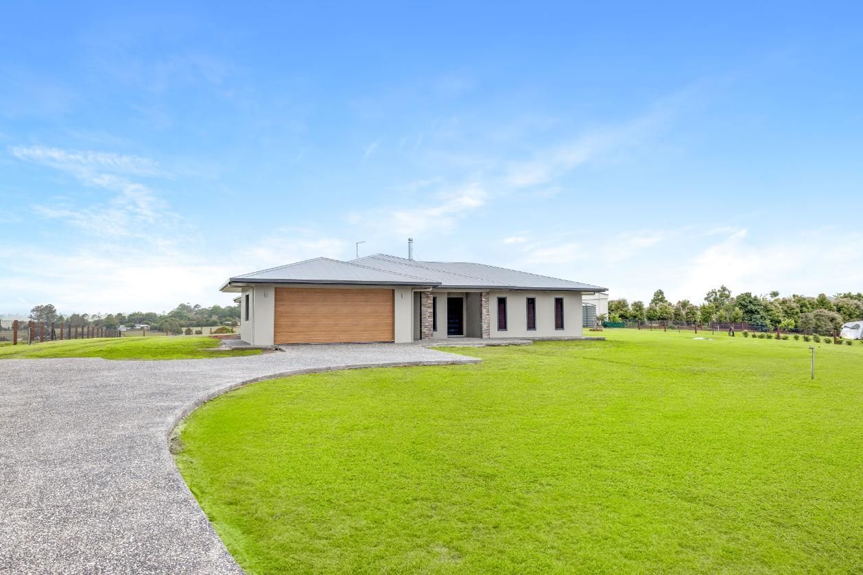 A House is Sitting on Top of a Lush Green Field — Ashlee Jones Homes in Gordonvale, QLD