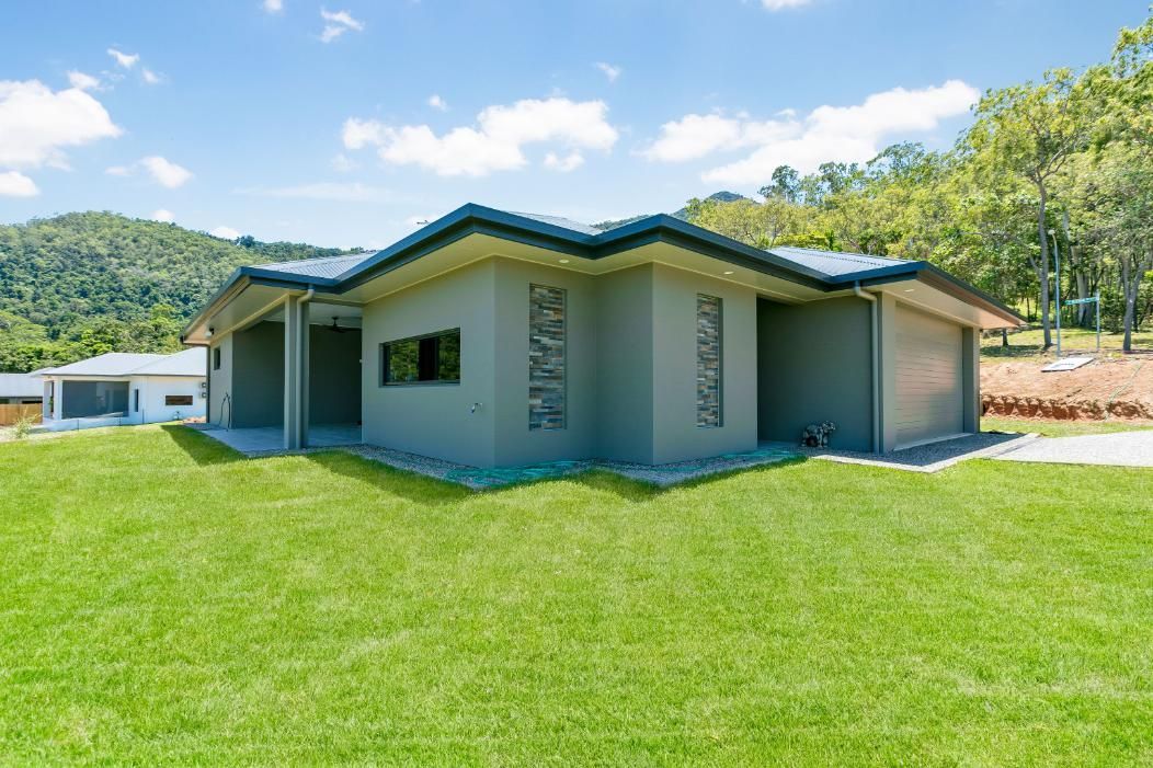 A House With a Lush Green Lawn in Front of It — Ashlee Jones Homes in Gordonvale, QLD