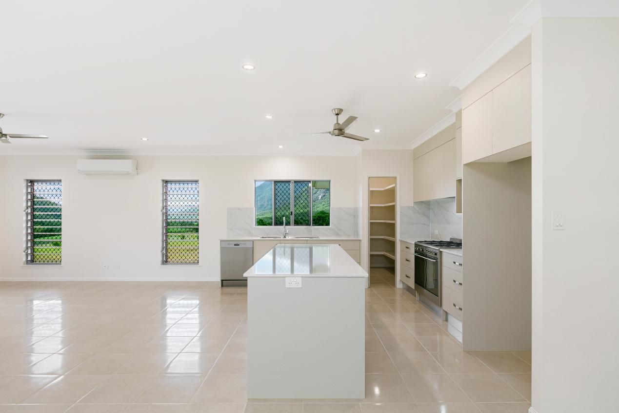An Empty Kitchen With a Large Island in the Middle of the Room — Ashlee Jones Homes in Gordonvale, QLD