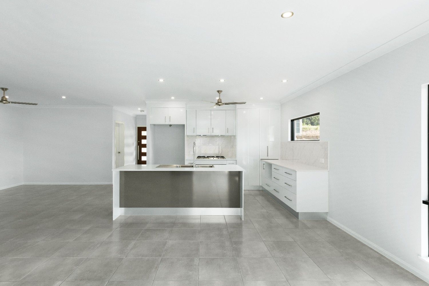 An Empty Room With Sliding Glass Doors and a Ceiling Fan — Ashlee Jones Homes in Gordonvale, QLD